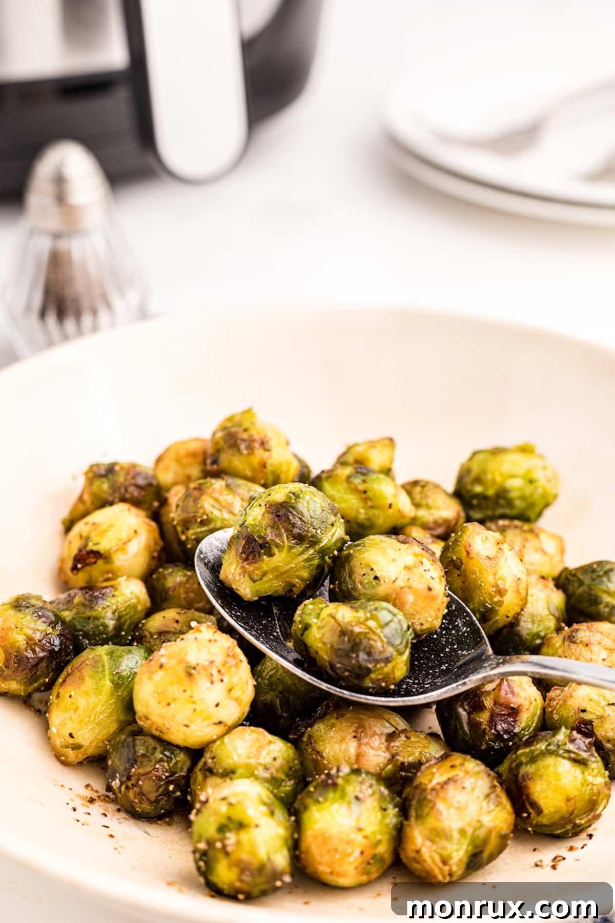 Close-up of perfectly cooked air fried brussels sprouts in a bowl, seasoned and ready to eat.