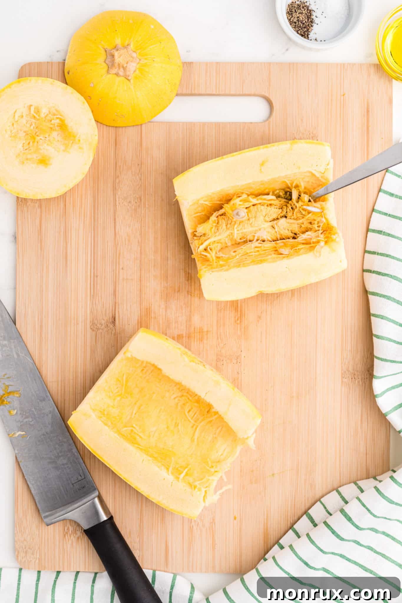 spaghetti squash cut in half on cutting board.