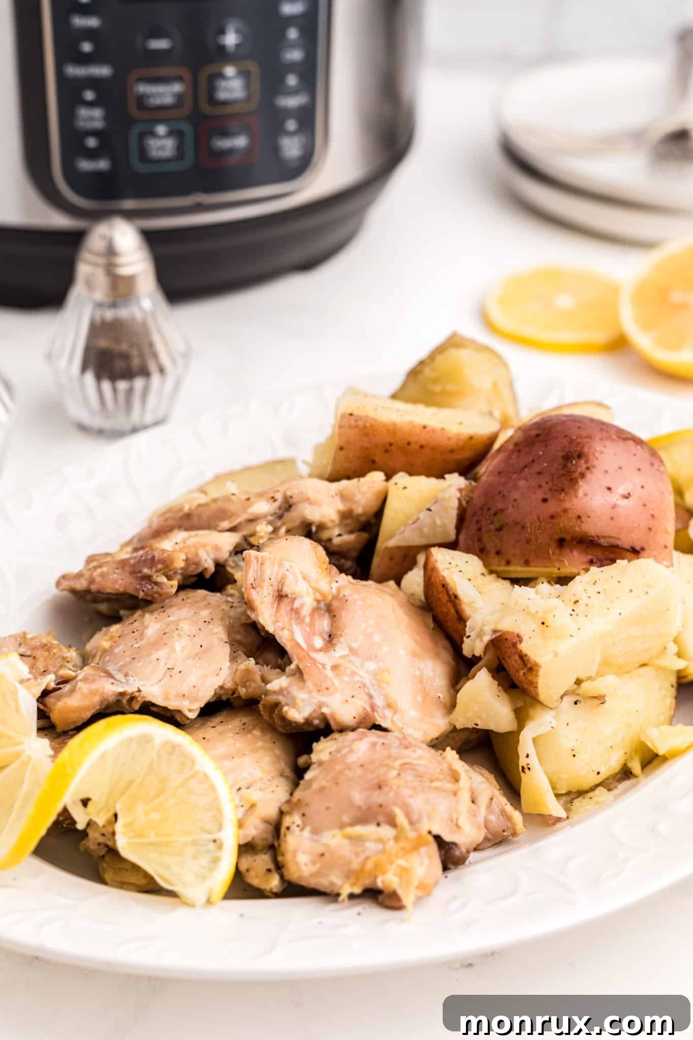 A perfectly cooked Instant Pot chicken thigh and potato dish, garnished with fresh herbs, ready to be served.