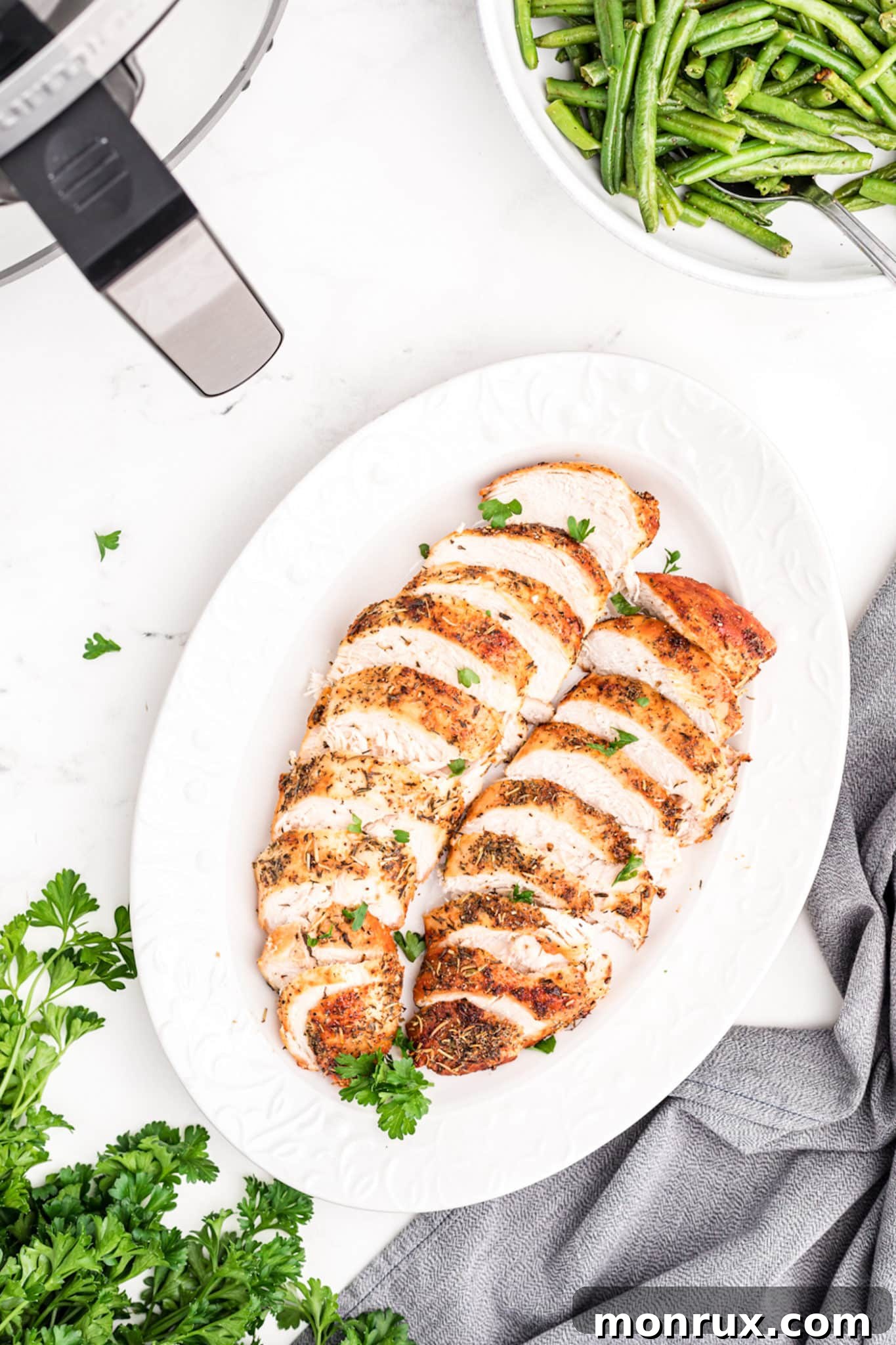 air fried turkey tenderloins sliced on a platter.