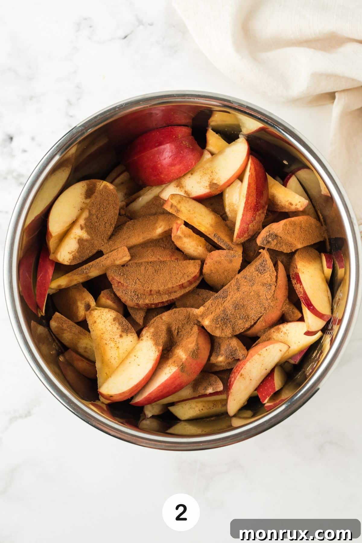 Chopped apples inside an Instant Pot pressure cooker with liquid and spices.