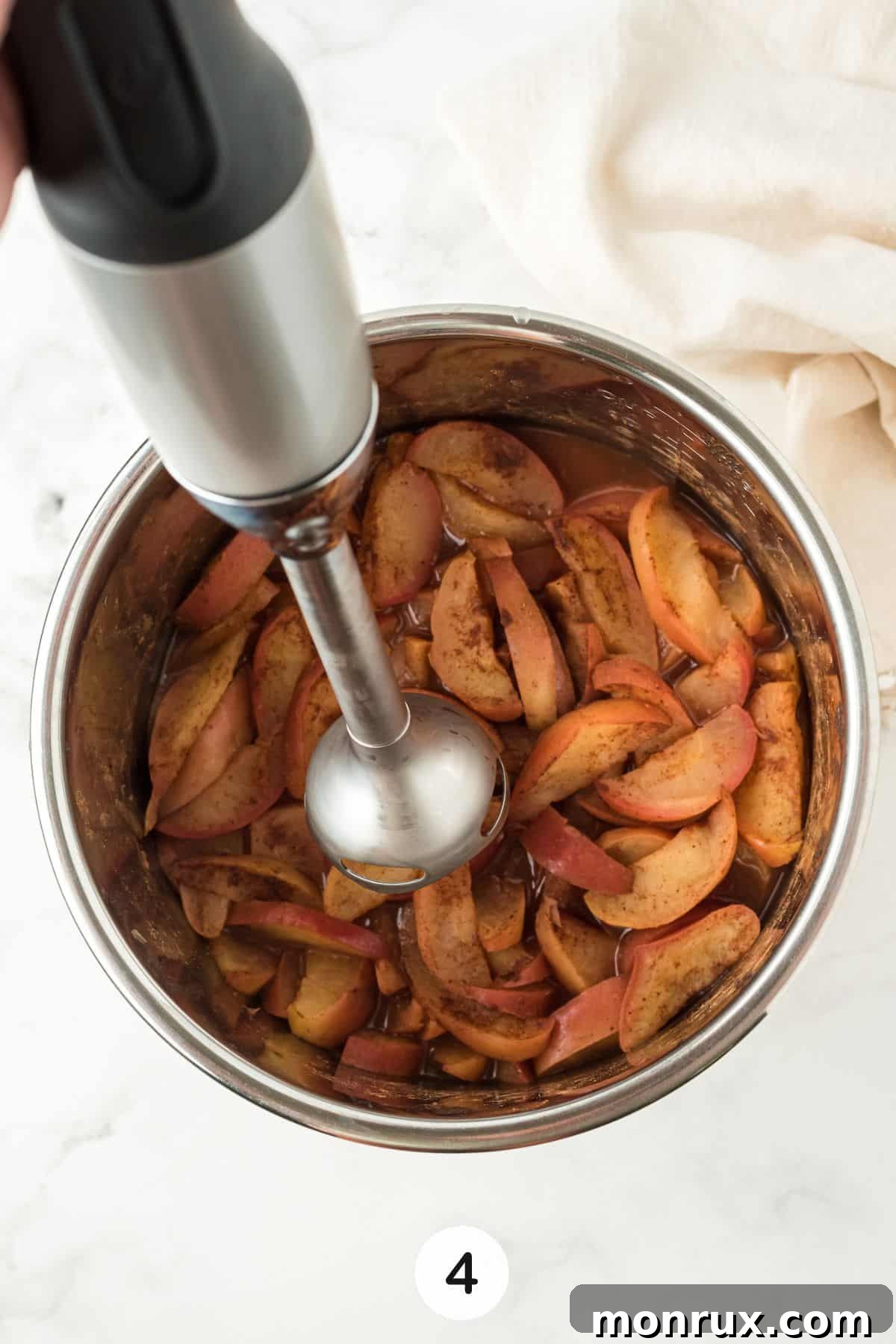 Using a hand immersion blender on the cooked apples in the Instant Pot.