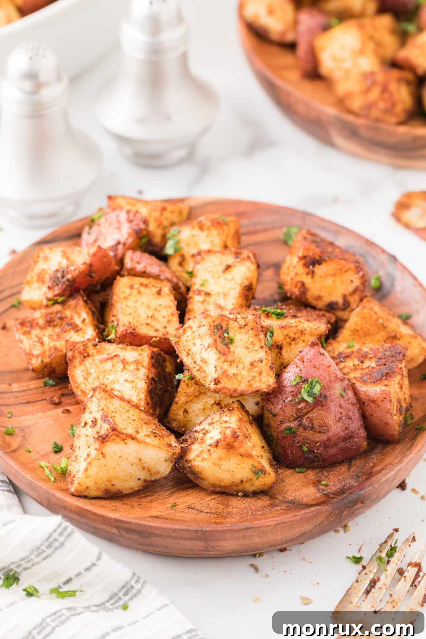 A vibrant serving of crispy baked Mexican potatoes on a plate, garnished with fresh cilantro.