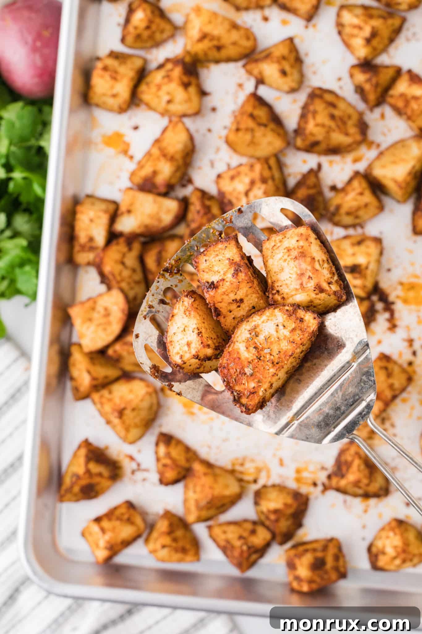 Cooked Mexican potatoes on a baking sheet, freshly removed from the oven, showing their golden-brown color.