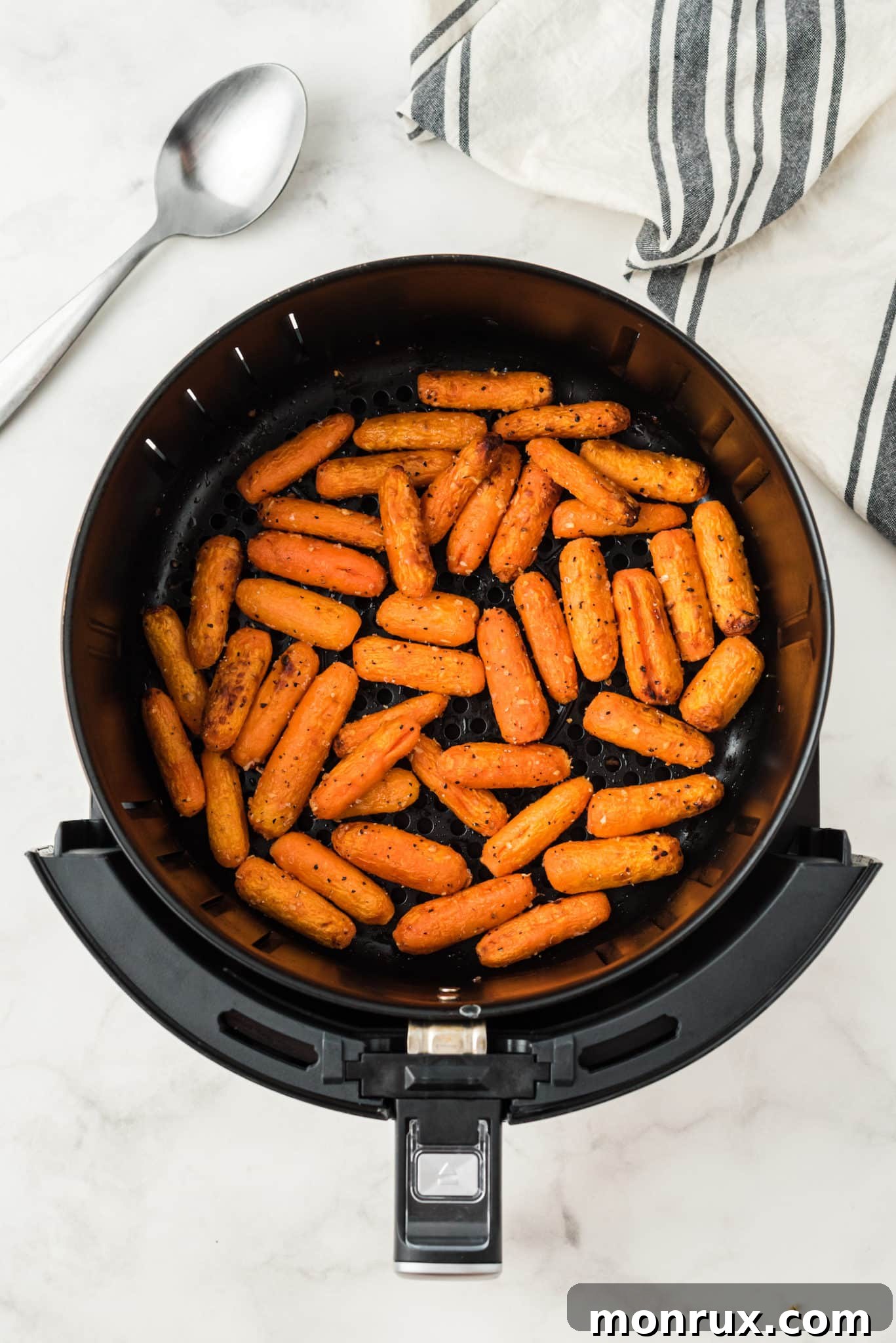 Beautifully glazed baby carrots cooked to perfection in an air fryer basket.
