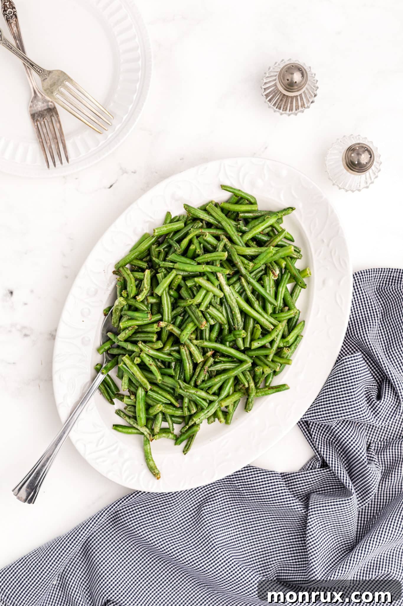 A beautifully arranged serving platter with air-fried green beans, garnished and ready for a meal.