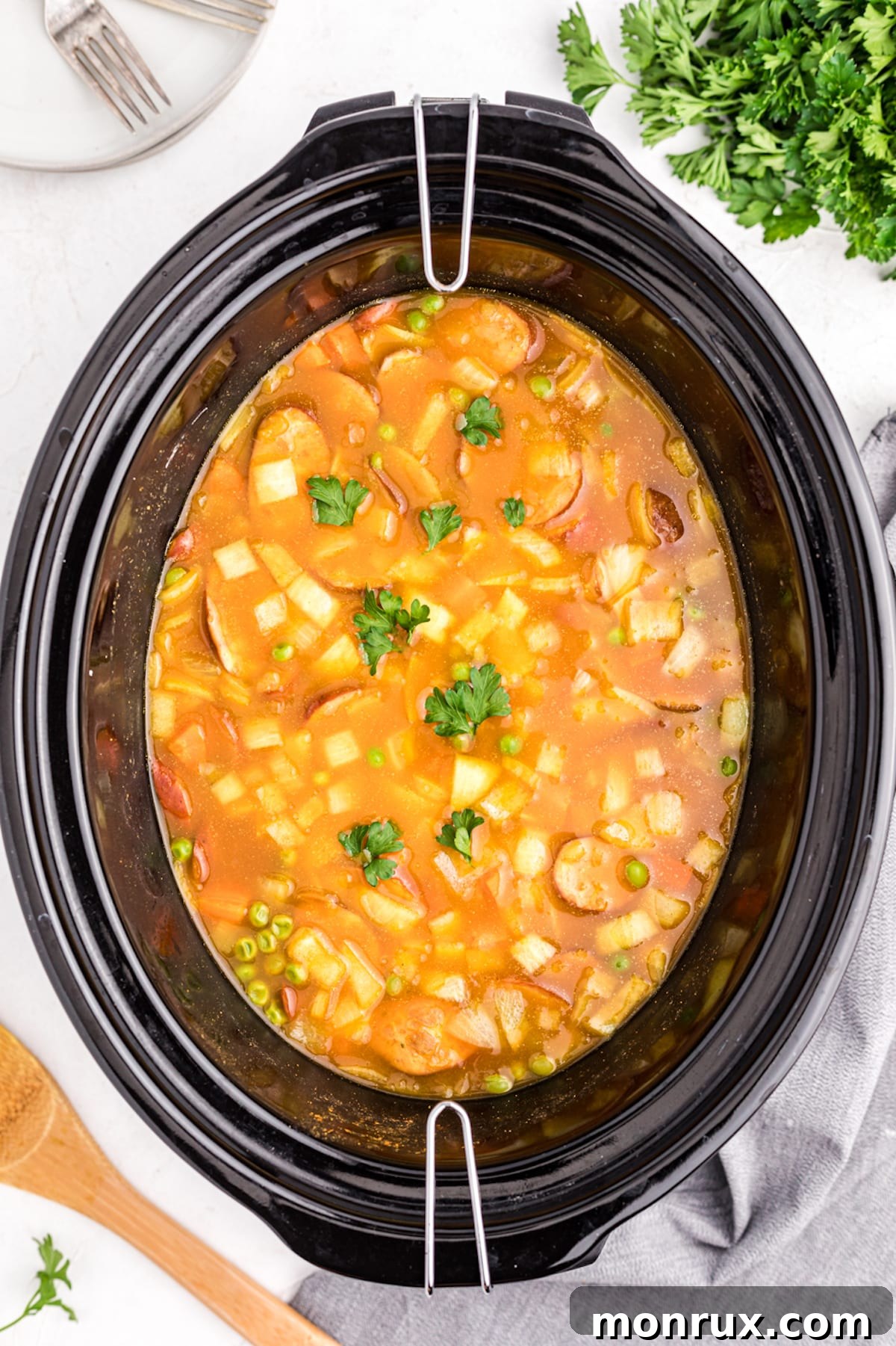 A close-up view of the cooked Slow Cooker Sausage Curry bubbling gently in the slow cooker.