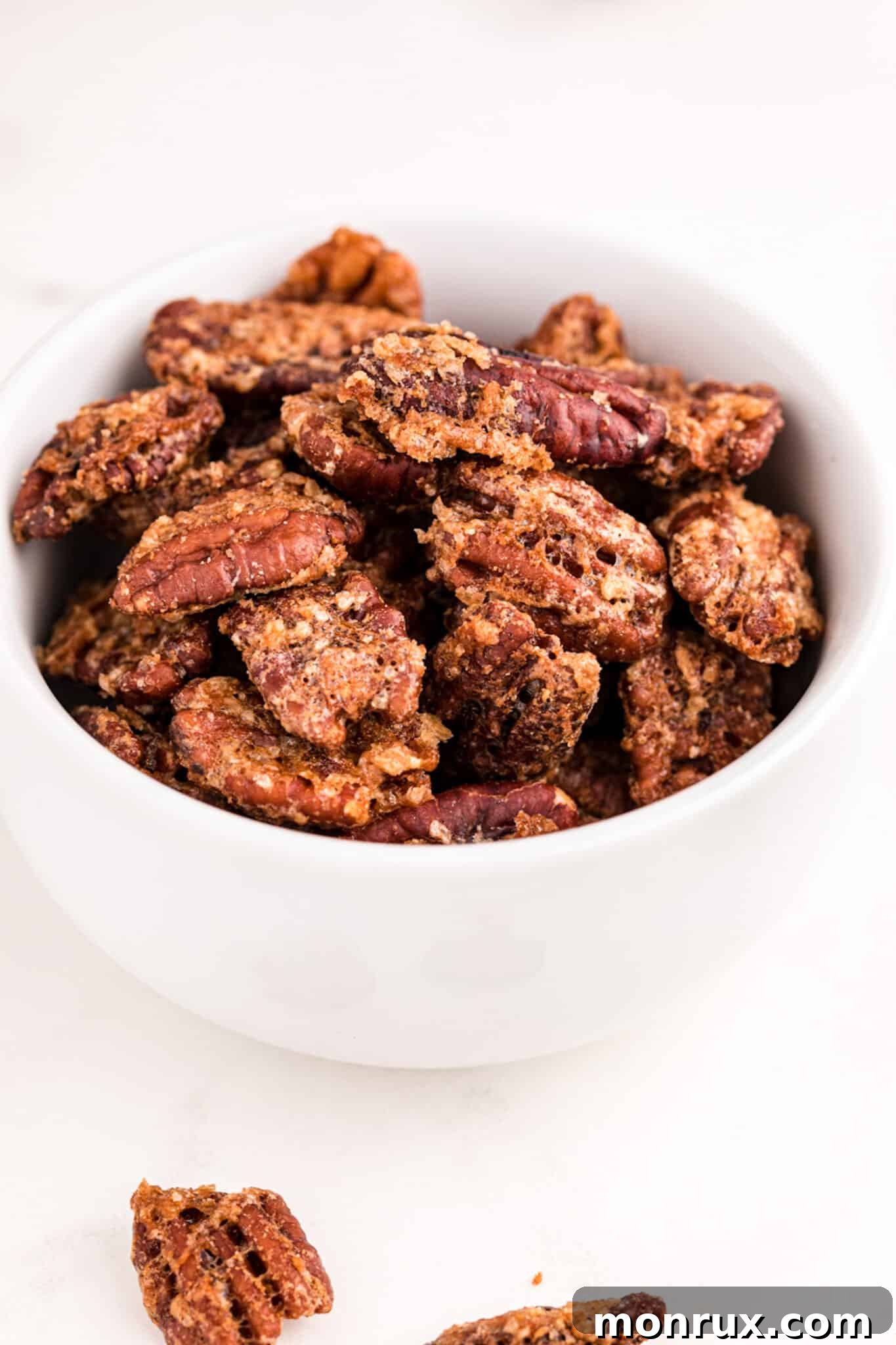 A serving bowl filled with freshly air fried candied pecans, glistening and ready to be enjoyed.