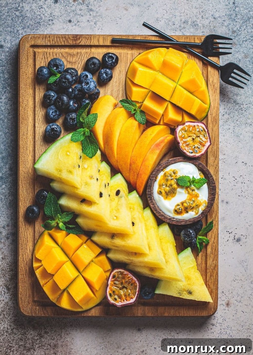 A colorful fruit snack board featuring an assortment of fresh berries, melon, grapes, and other seasonal fruits, artfully arranged for a healthy and delicious treat.