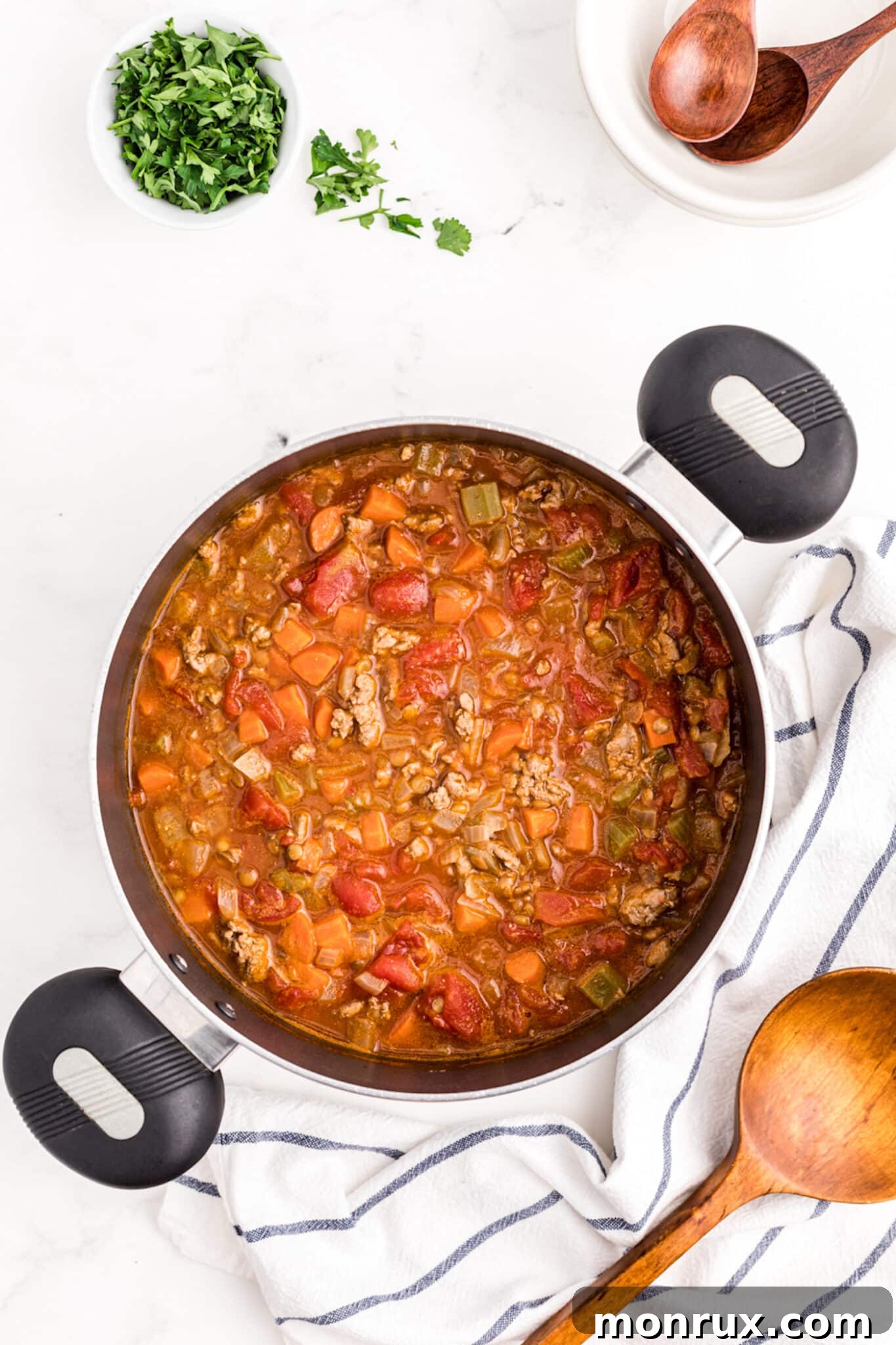 Hearty ground turkey lentil soup simmering gently in a large pot on the stovetop, developing rich flavors.