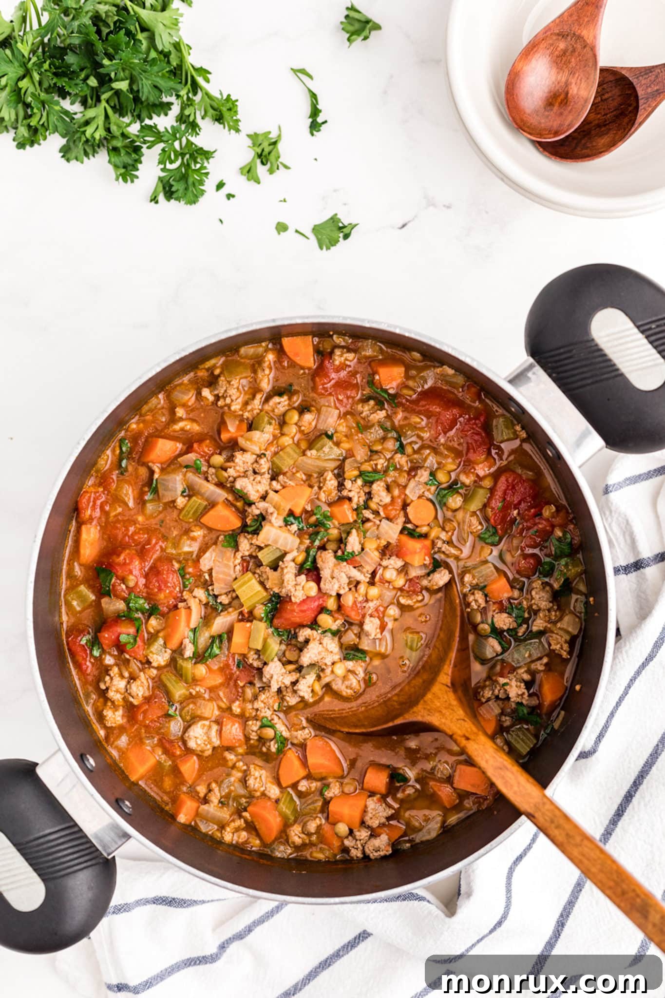 A close-up of hearty cooked lentil turkey soup in a rustic pot, ready to be served and enjoyed.