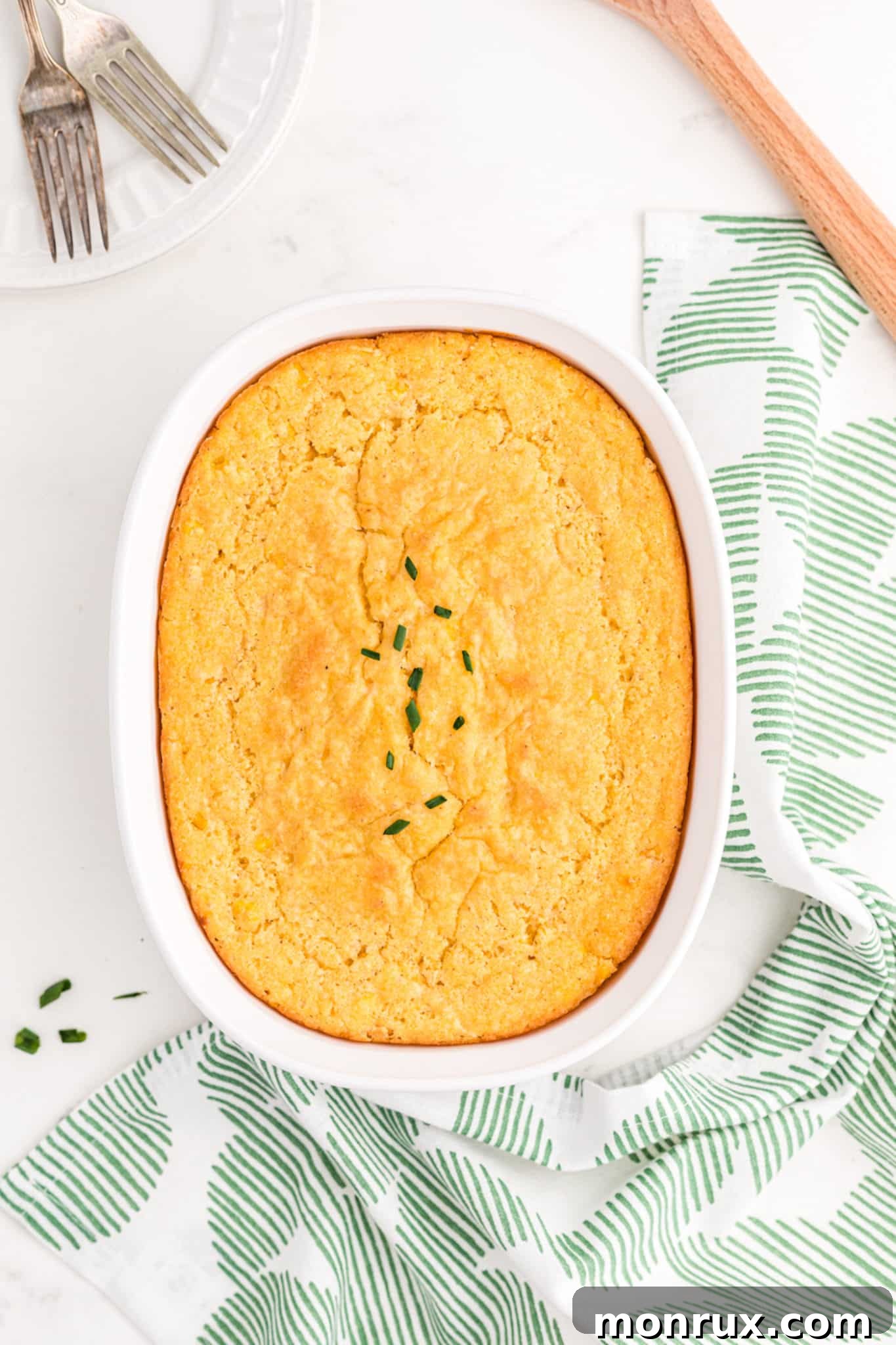 Dairy-free corn casserole served in a beautiful baking dish on a rustic table, ready for a holiday meal.