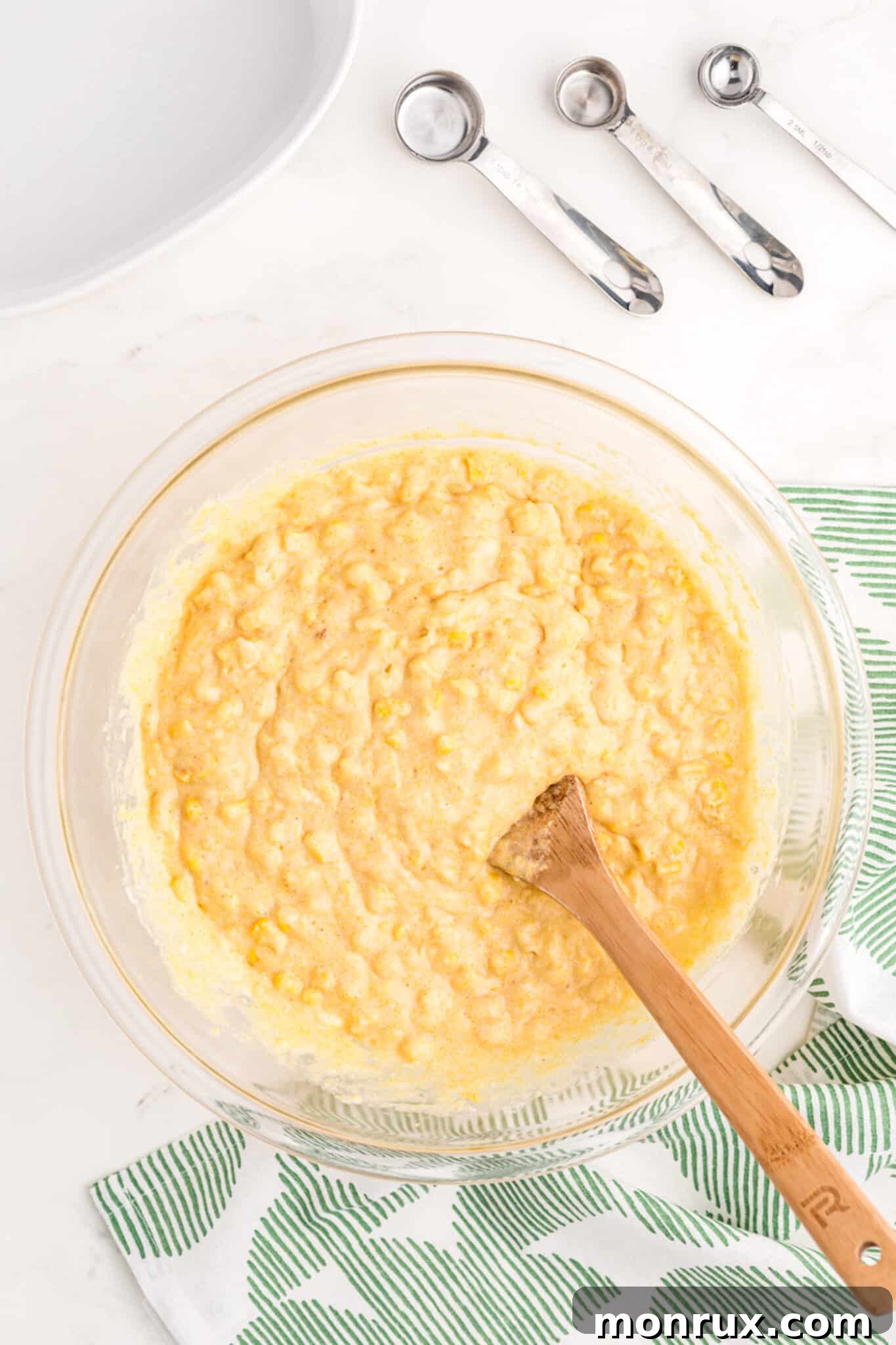 Gently mixed corn casserole ingredients in a bowl, showing the creamy batter consistency.