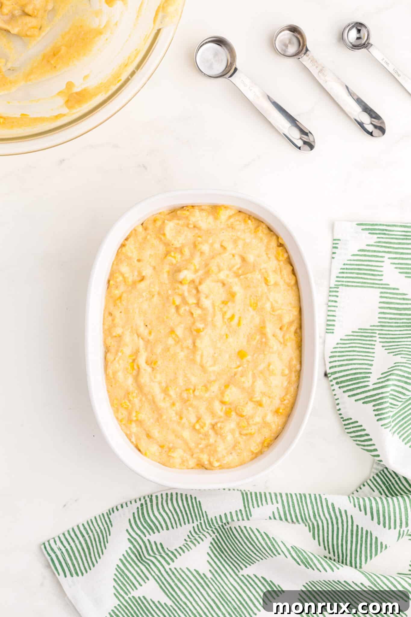 Corn casserole batter poured into a baking dish, ready for the oven.