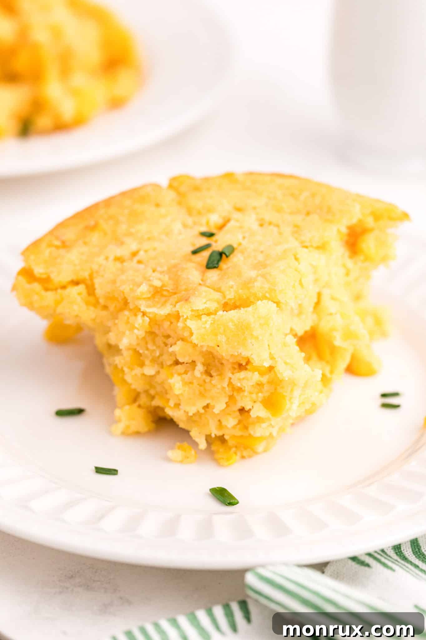 A perfectly sliced piece of dairy-free corn casserole on a plate, highlighting its moist and sweet texture.