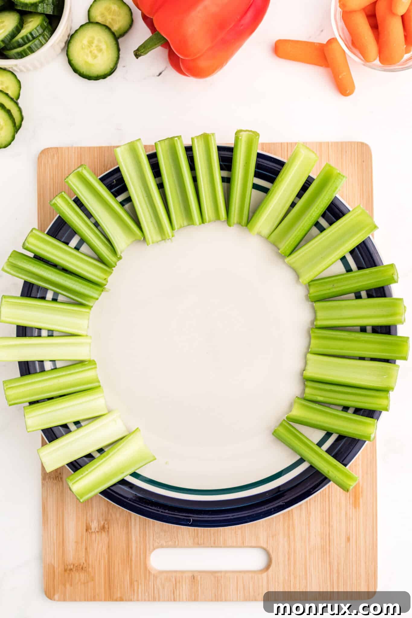 Celery sticks arranged in a semi-circle on a platter, forming the first layer of the turkey's tail.
