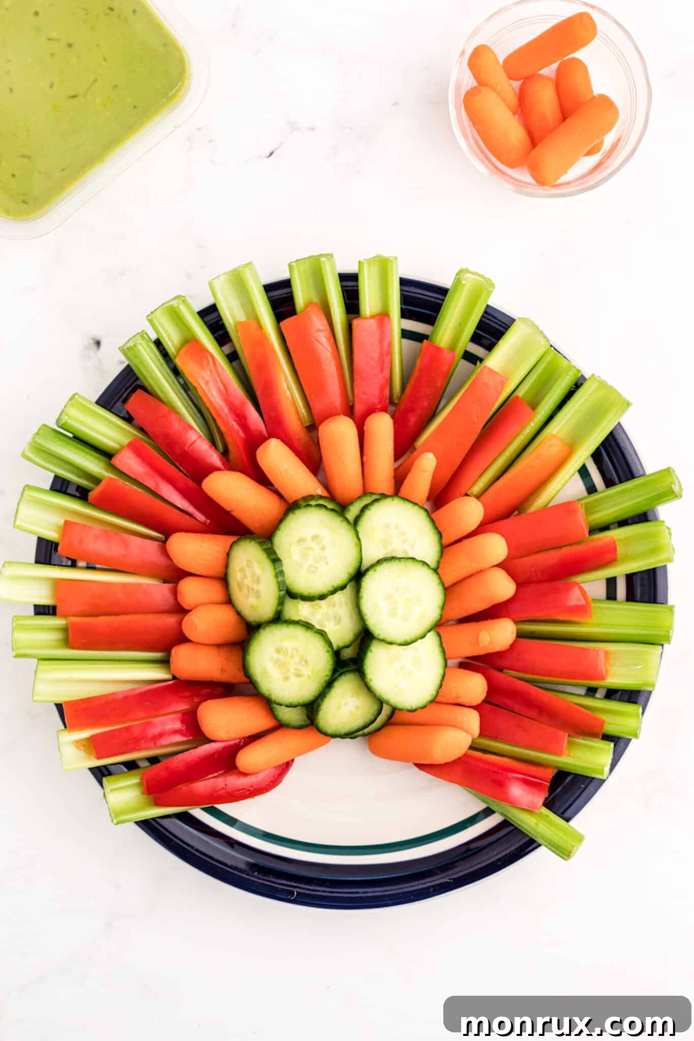 A completed turkey-shaped vegetable tray with all vegetables arranged, ready for the head.