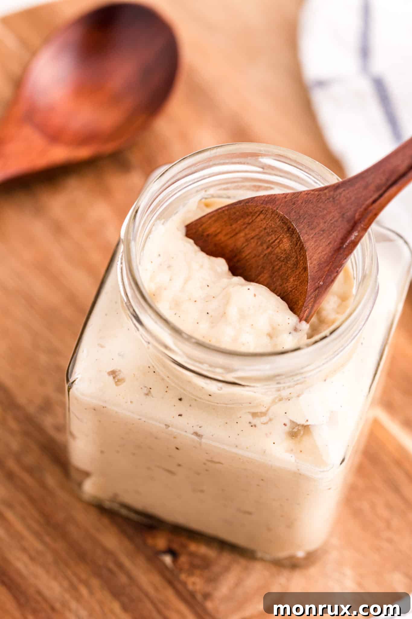 Homemade gluten-free and dairy-free cream of chicken soup in a glass jar with a spoon.