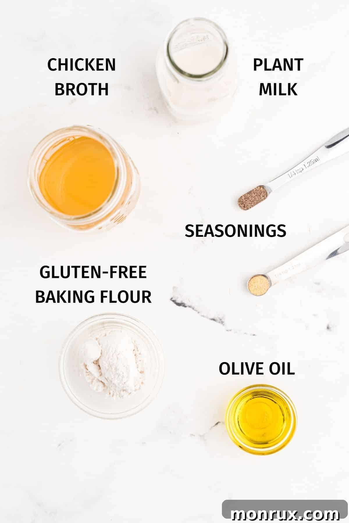 A collection of fresh ingredients laid out on a table, including chicken broth, almond milk, gluten-free flour, and olive oil, ready for making cream of chicken soup.