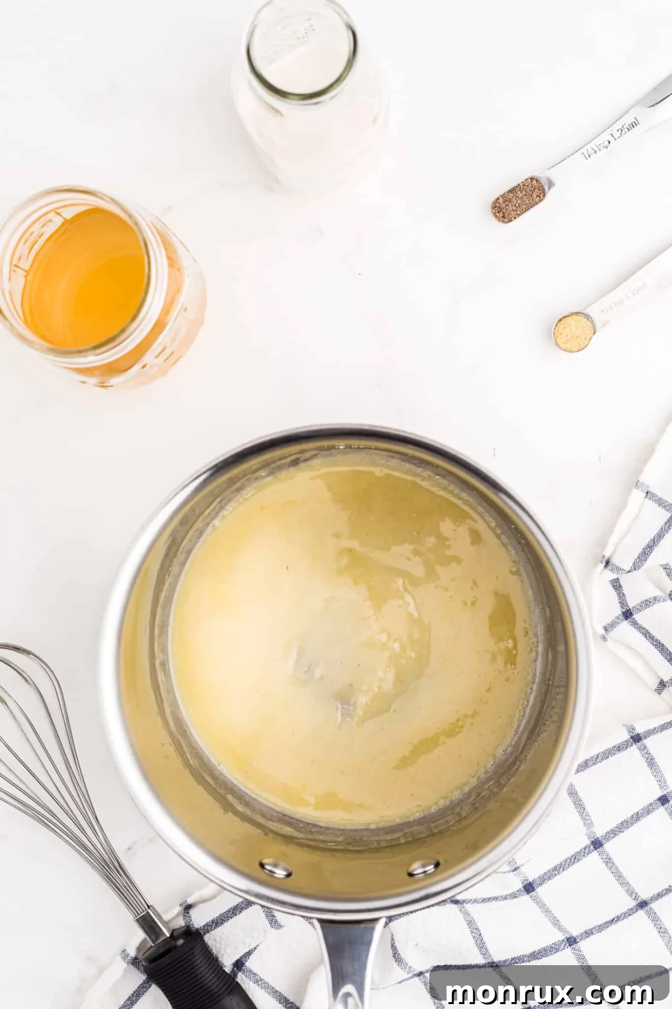 Ingredients for gluten-free dairy-free cream of chicken soup simmering in a saucepan.