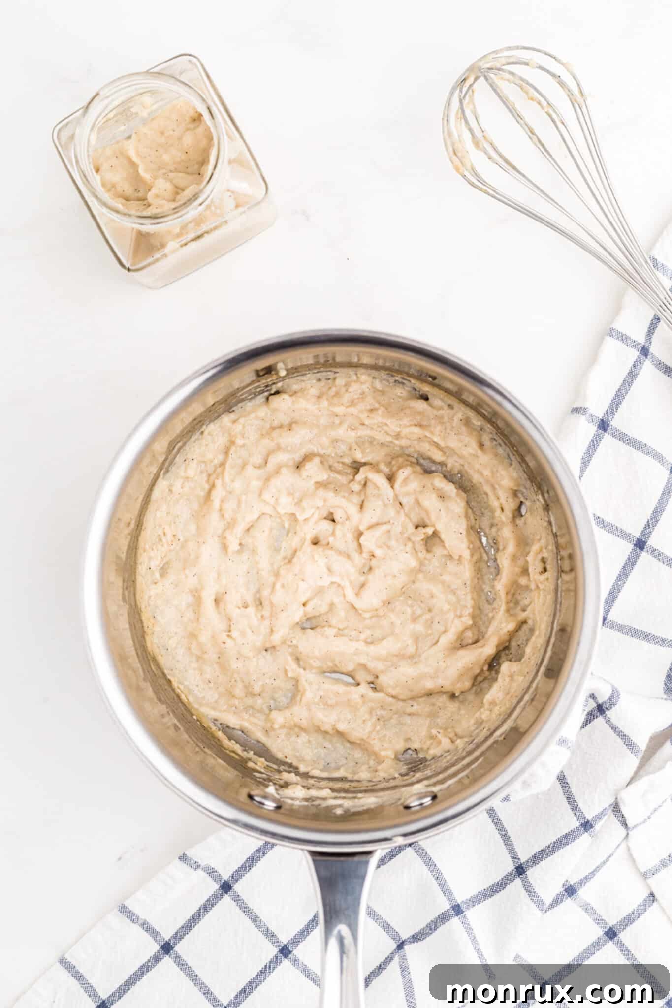 Thickened creamy mixture for dairy-free cream of chicken soup in a saucepan.