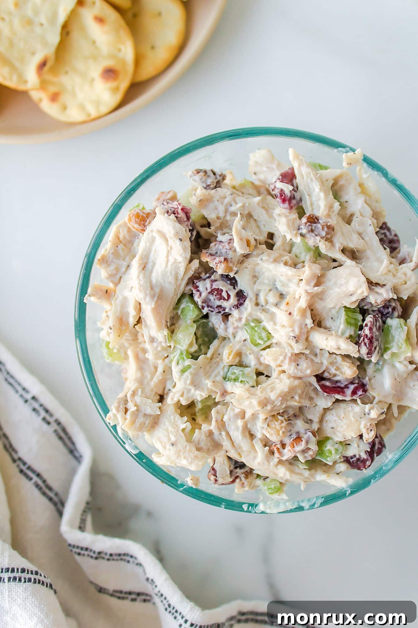 A beautifully presented bowl of creamy Cranberry Walnut Chicken Salad, garnished with fresh herbs, showcasing the vibrant colors and appealing texture.
