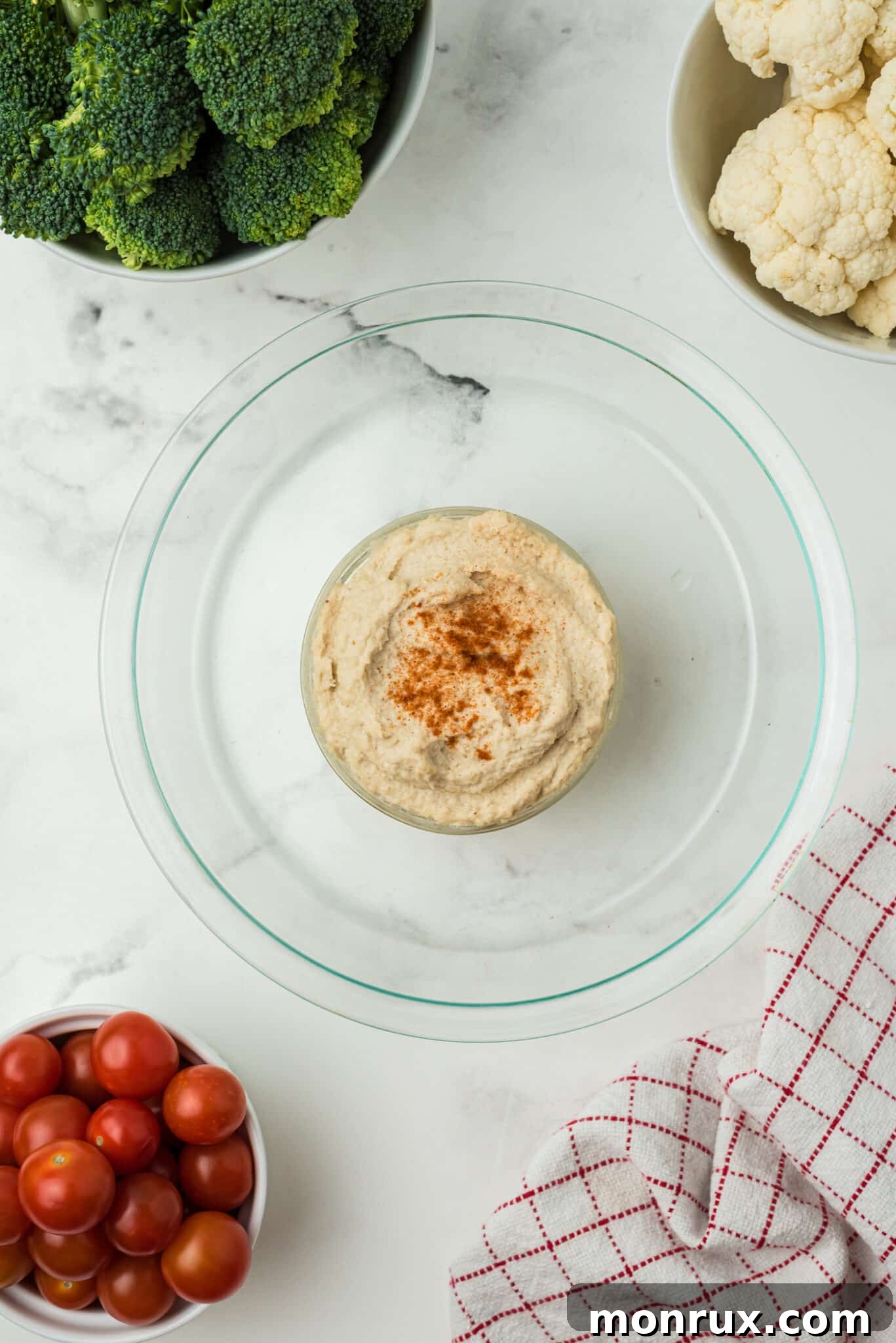 A bowl of creamy dip placed in the center of a serving dish, ready for the Christmas veggie wreath assembly.