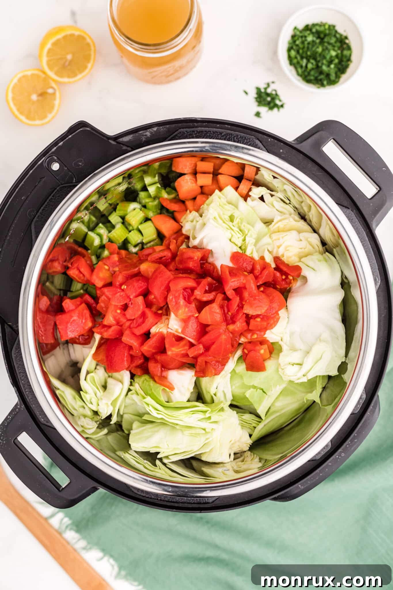 All raw ingredients for cabbage veggie soup placed inside an Instant Pot for cooking.