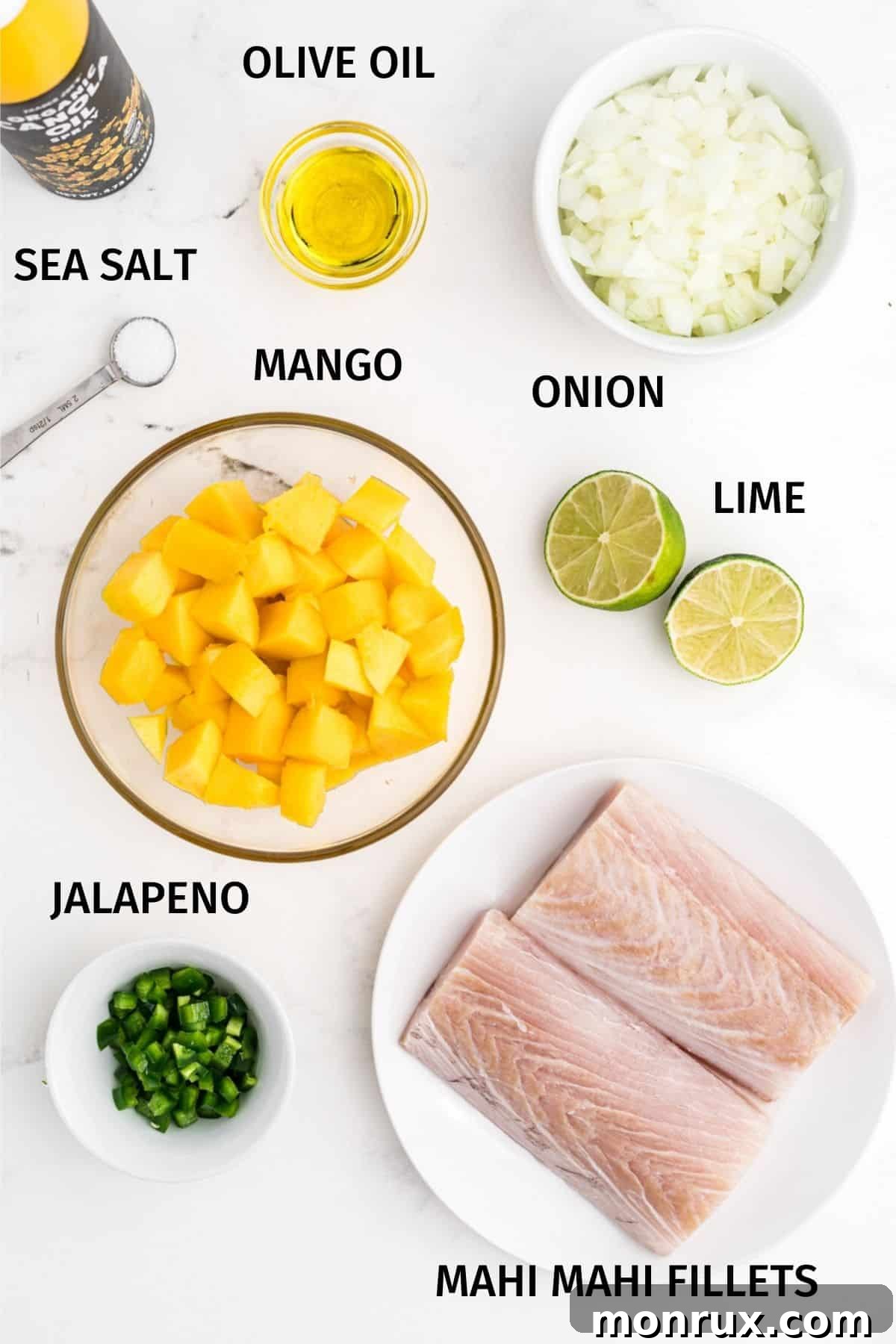 ingredients for mahi mahi and mango salsa arranged on a white surface.