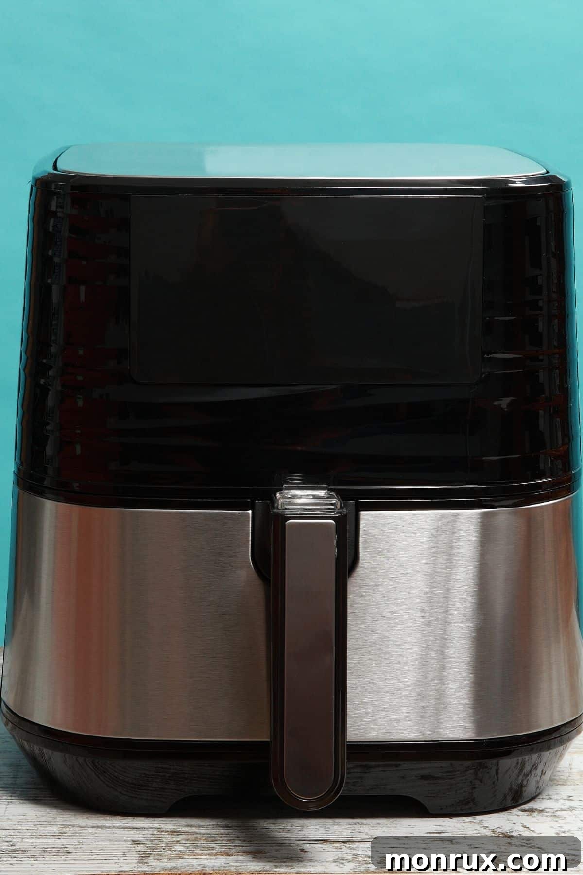 A modern air fryer sits on a clean kitchen countertop, ready for use.