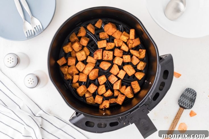 Crispy air fryer sweet potato cubes seasoned with cinnamon.