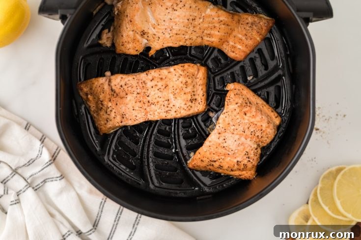 Baked salmon in an air fryer basket.