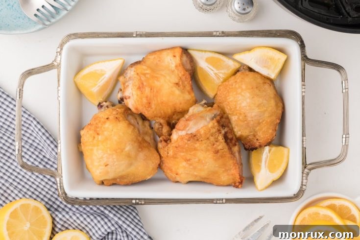 Platter of air fried bone-in chicken thighs with crispy skin.