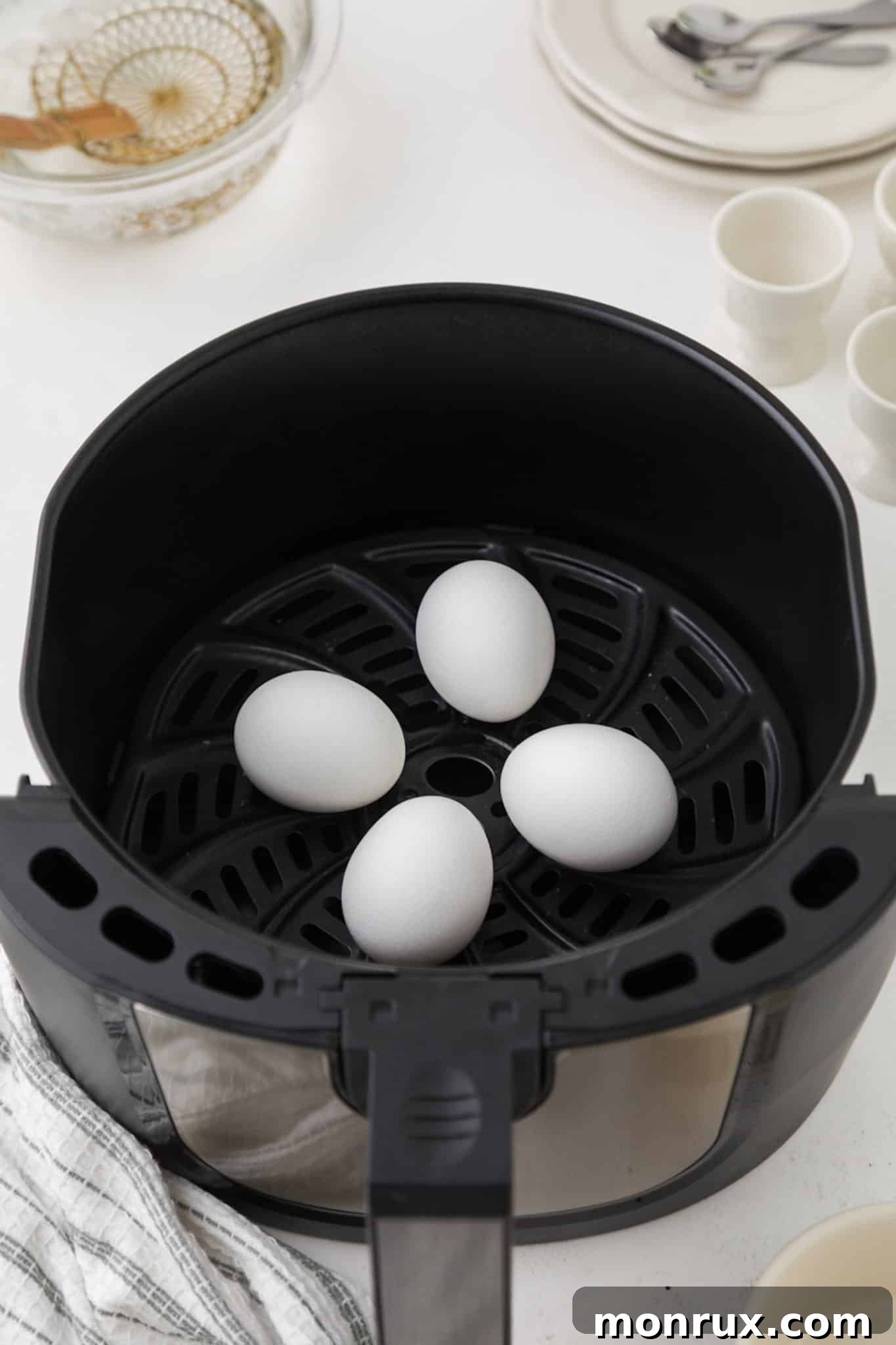 Cooked eggs resting inside the air fryer basket after cooking.