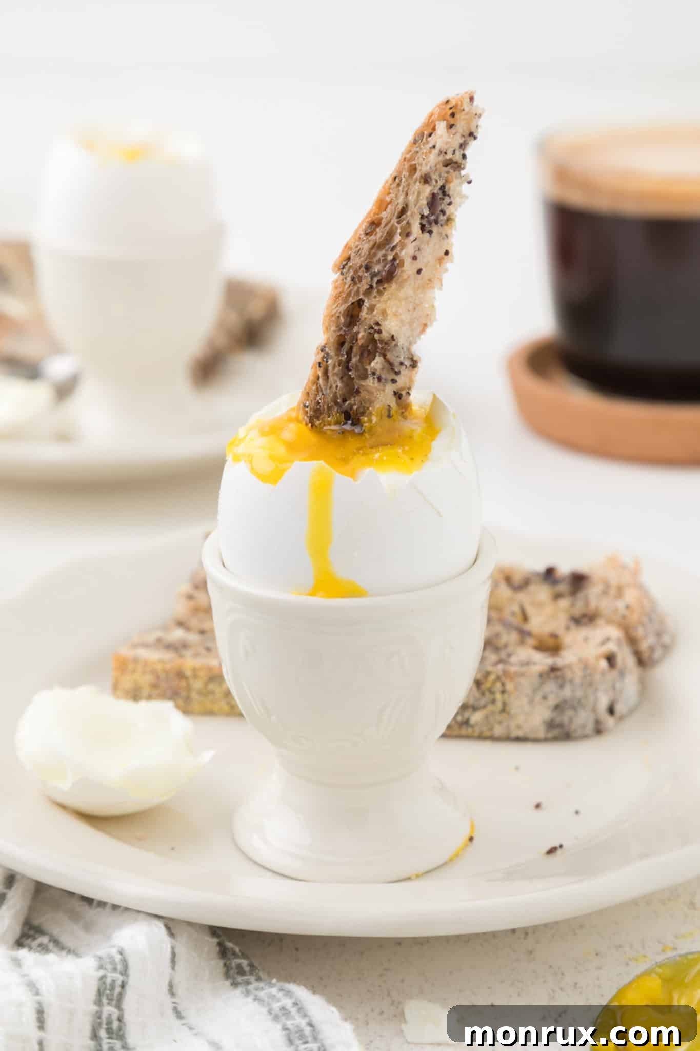Toast being dipped into a soft boiled egg in an egg cup.