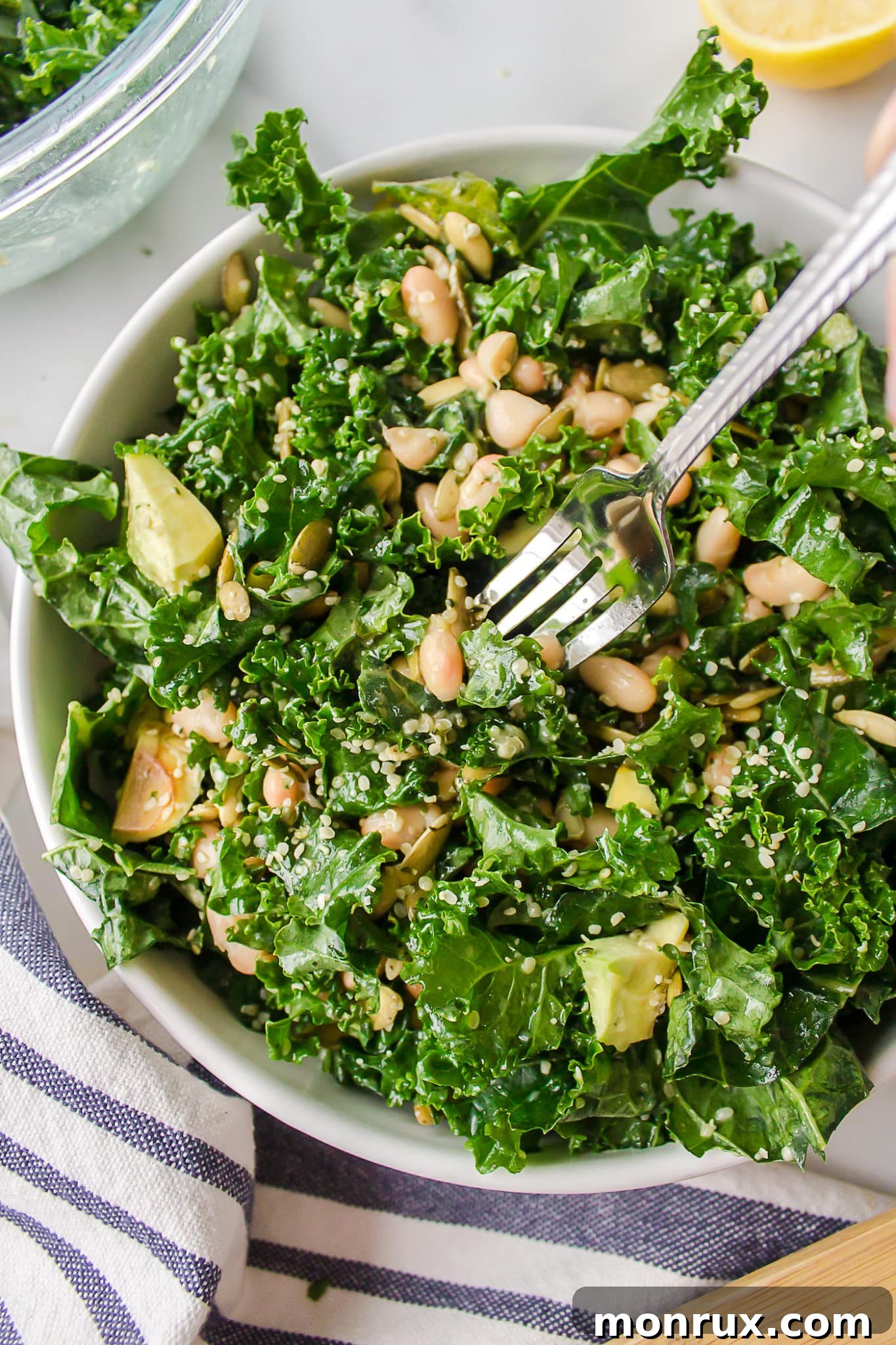 A bowl of the finished Erewhon kale salad with a fork, highlighting its fresh and inviting appearance.