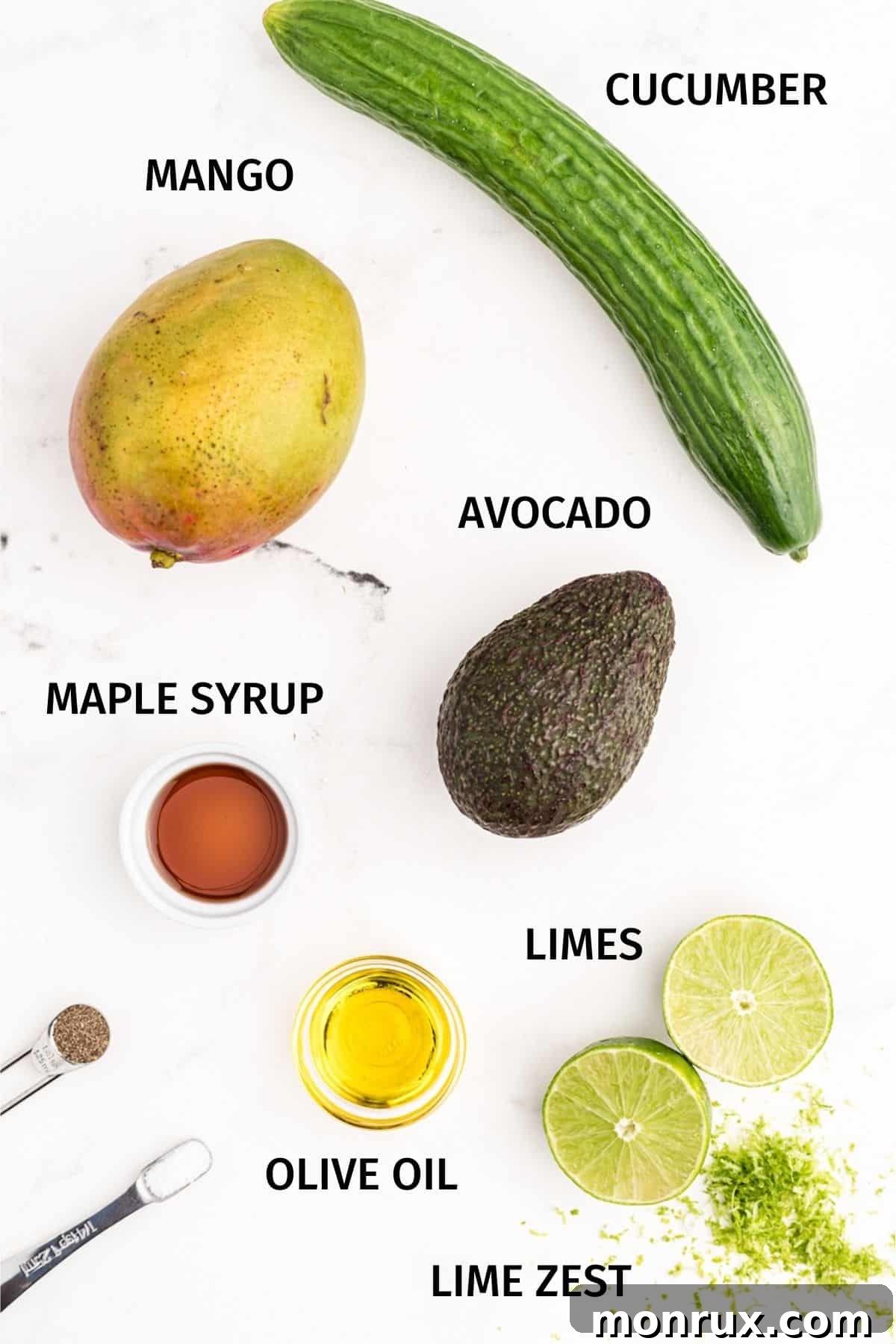 A flat lay image showcasing the fresh ingredients for mango avocado salad, including ripe mango, avocado, cucumber, and limes.