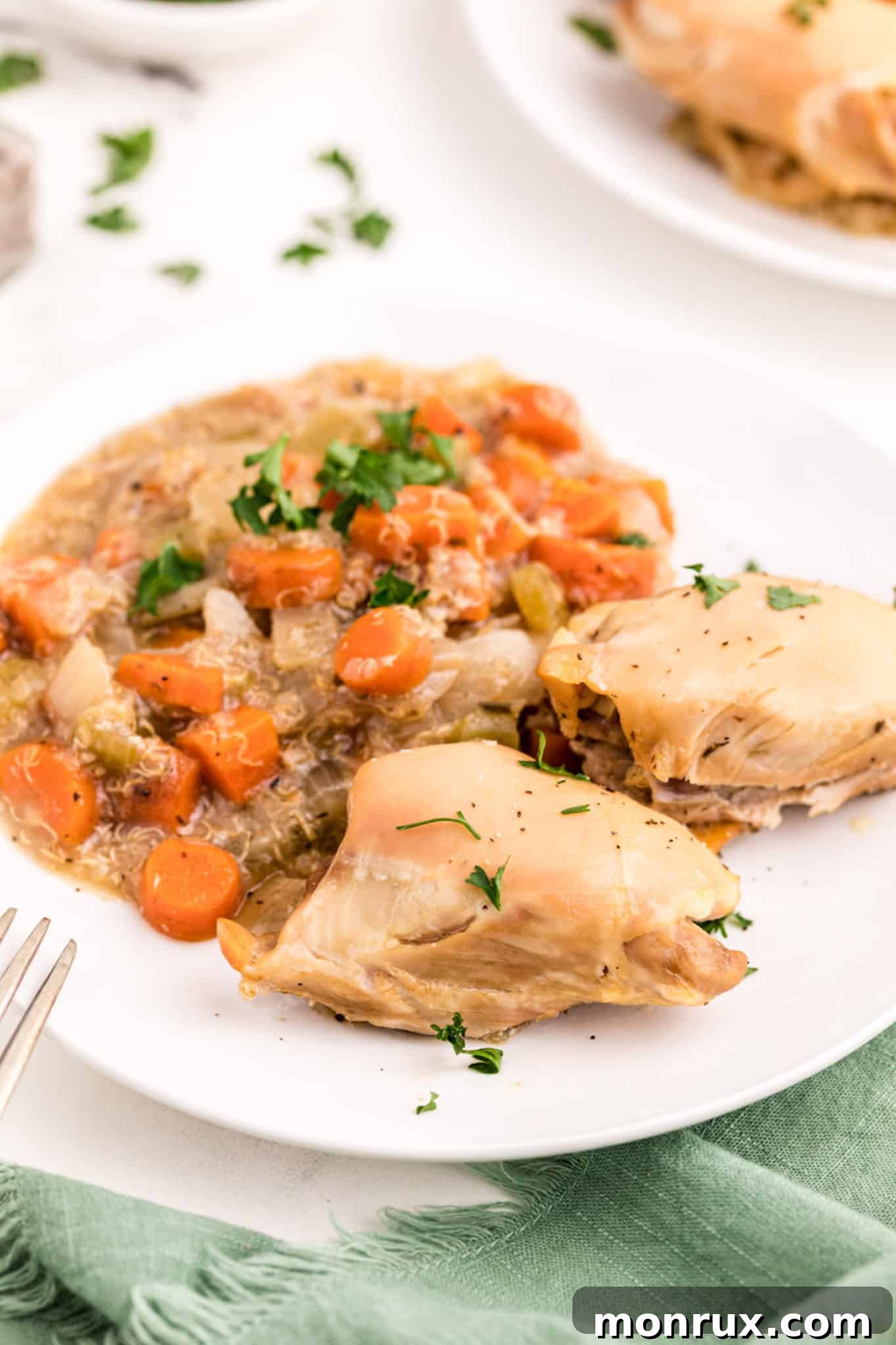 A serving of slow cooker chicken, carrots, and quinoa on a plate, ready to be enjoyed.