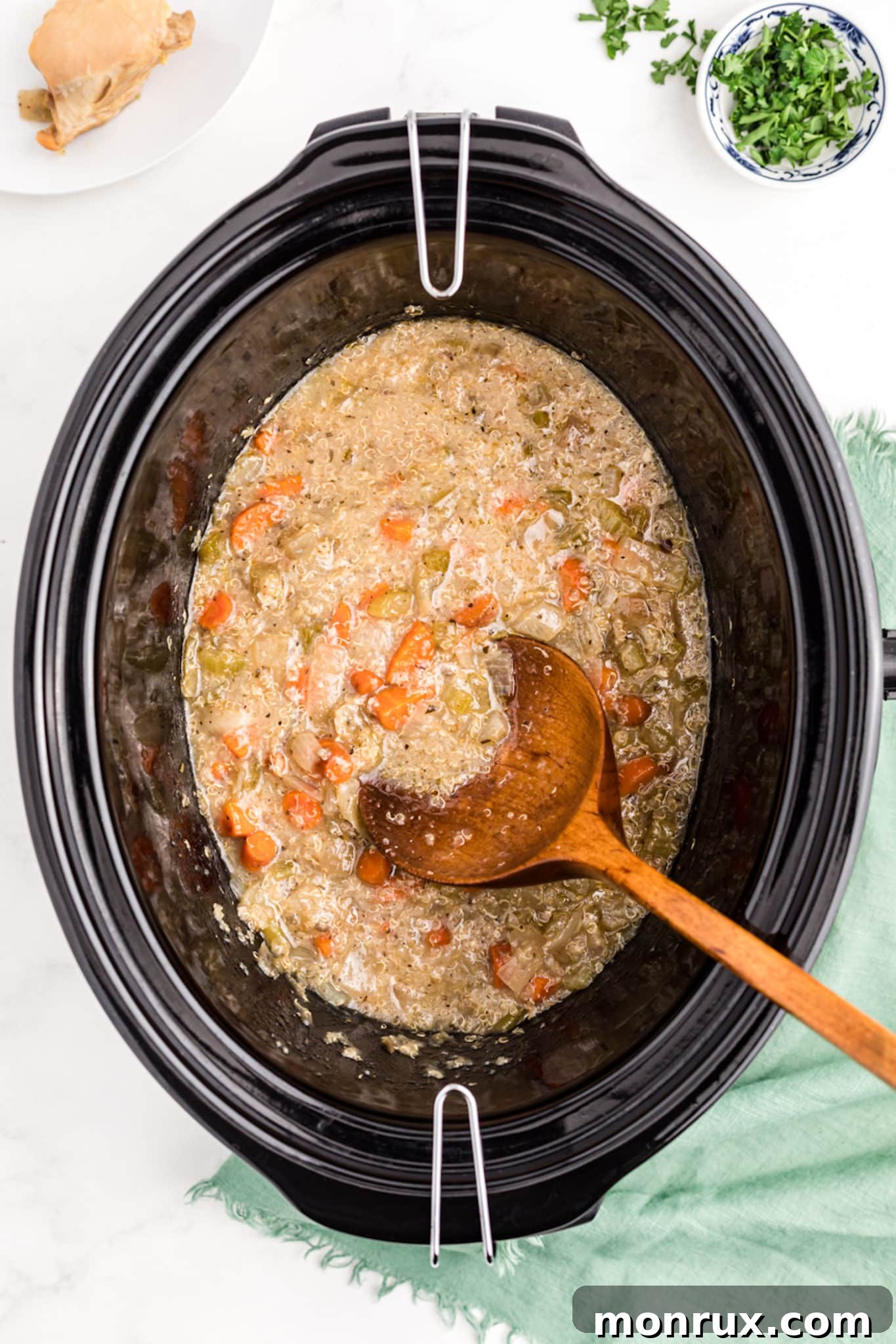 Cooked quinoa and chicken stew simmering inside a crockpot, rich and ready to serve.