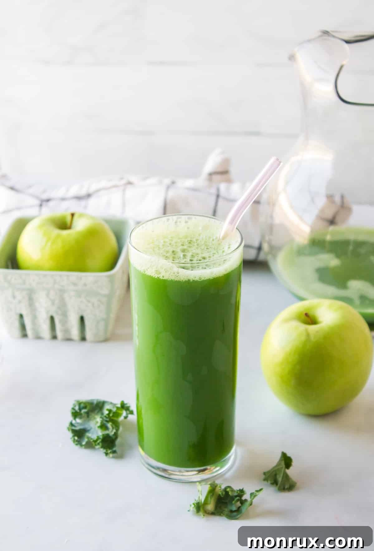 glass of green juice in clear glass with straw, showcasing a vibrant kale juice.