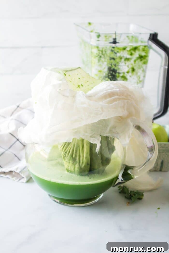straining kale juice through a nut milk bag.