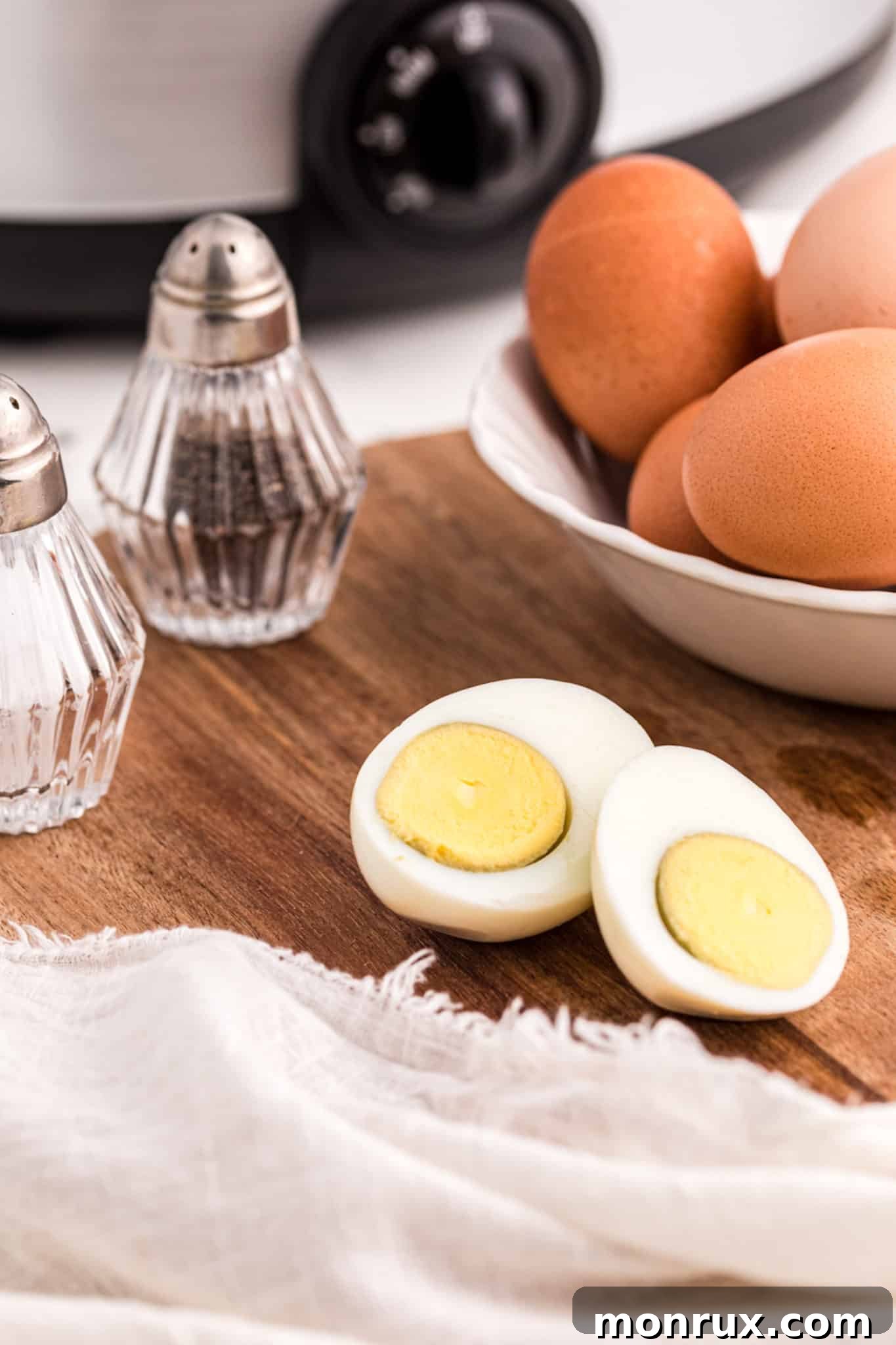 Cooked crockpot hard-boiled eggs, perfectly peeled and ready to enjoy, displayed on a plate.