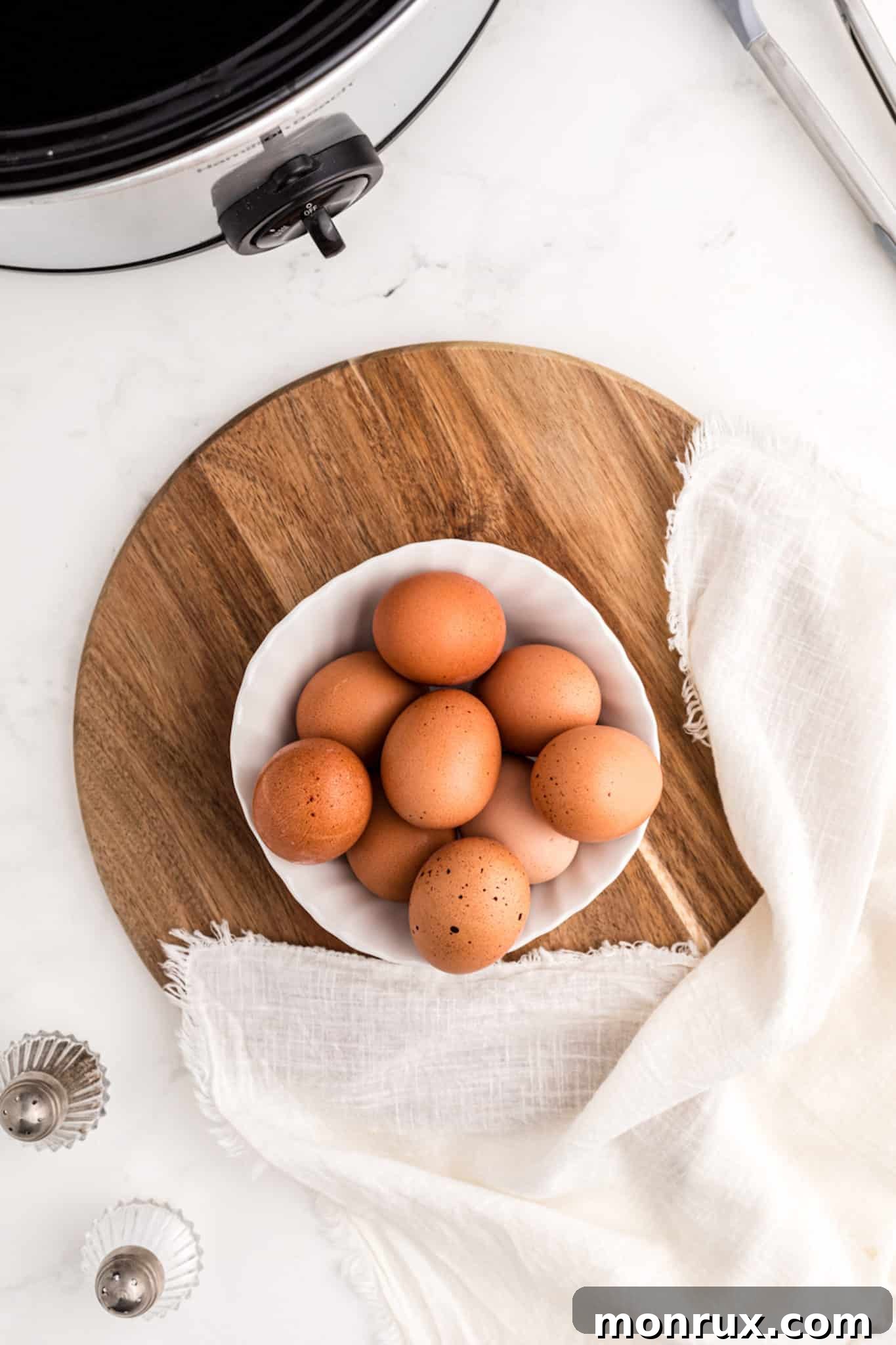 A bowl filled with freshly cooked crockpot hard-boiled eggs, ready to be peeled and served.