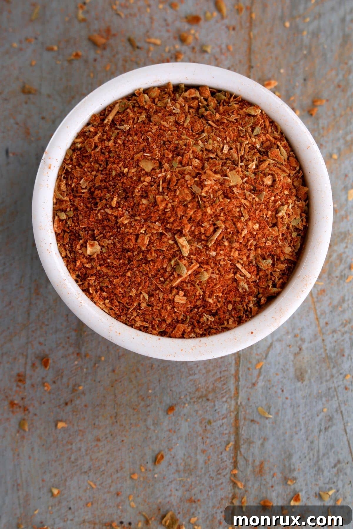 a bowl of sambar masala. A small wooden bowl containing Sambar Masala, a traditional South Indian spice blend, on a rustic background.