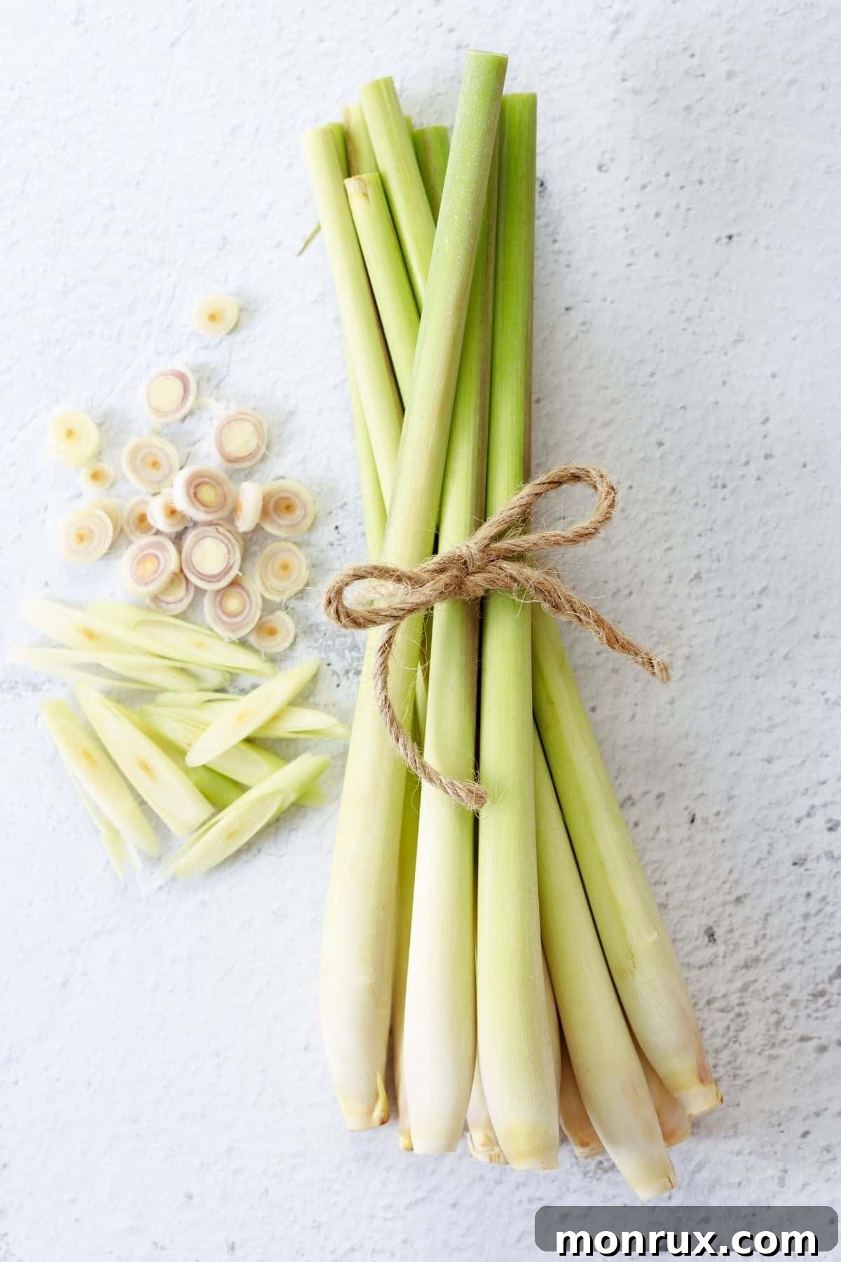 Close-up image of fresh lemongrass stalks on a rustic wooden table, highlighting their texture and vibrant green color.