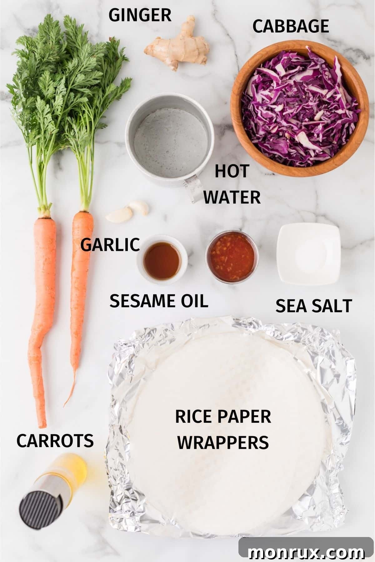 A vibrant display of fresh ingredients laid out for making spring rolls, including grated carrots, shredded cabbage, sesame oil, ginger, garlic, and rice paper wrappers.