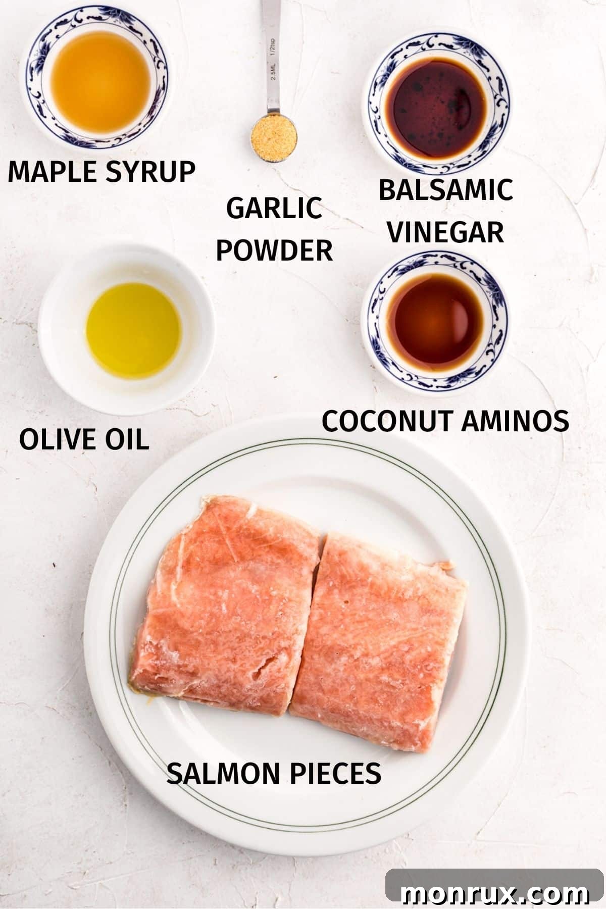 maple syrup, balsamic vinegar, olive oil, coconut aminos, and frozen salmon fillets arranged for a photo.