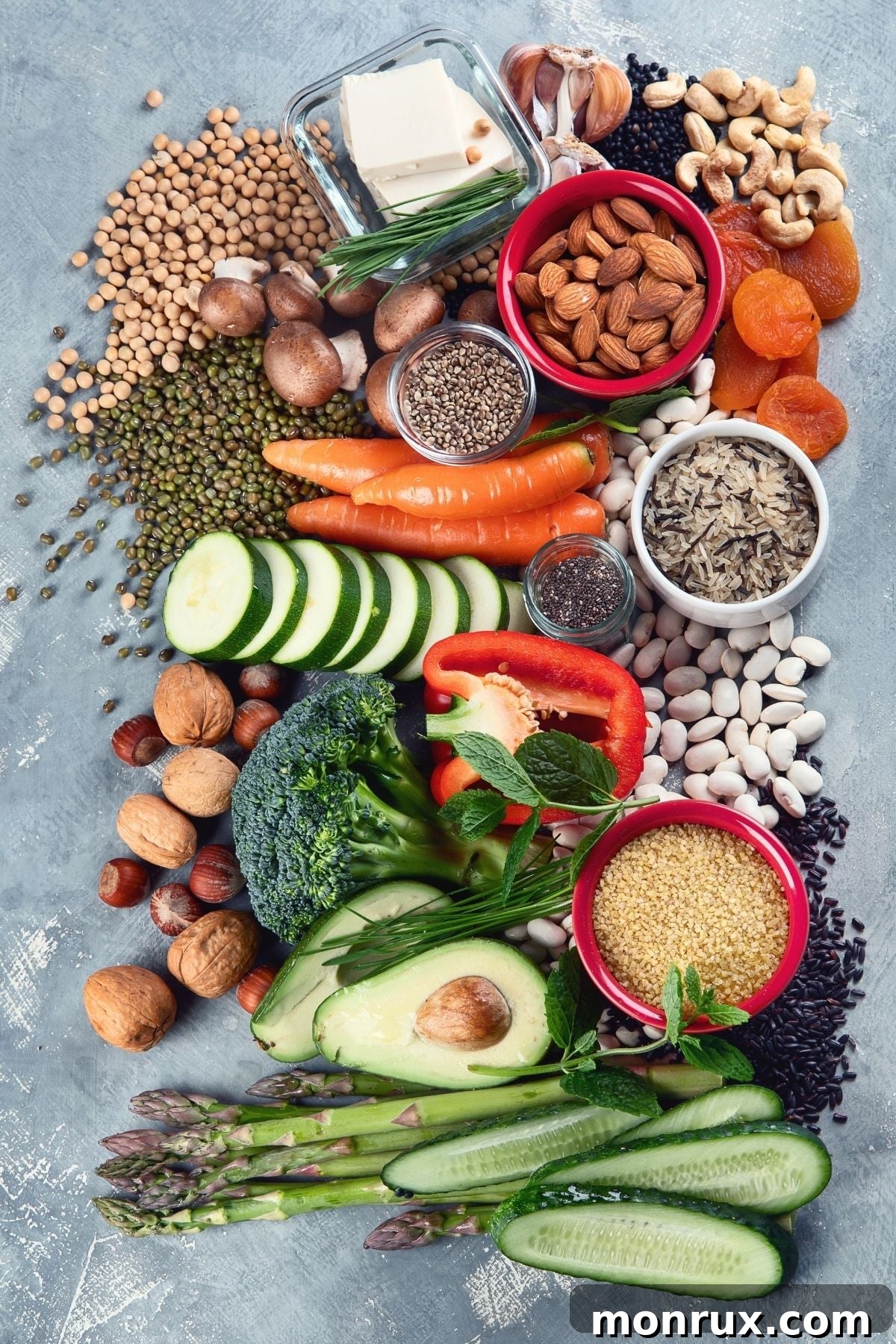 A diverse assortment of fresh fruits, vegetables, grains, and legumes laid out on a table, representing a wholesome plant-based diet.
