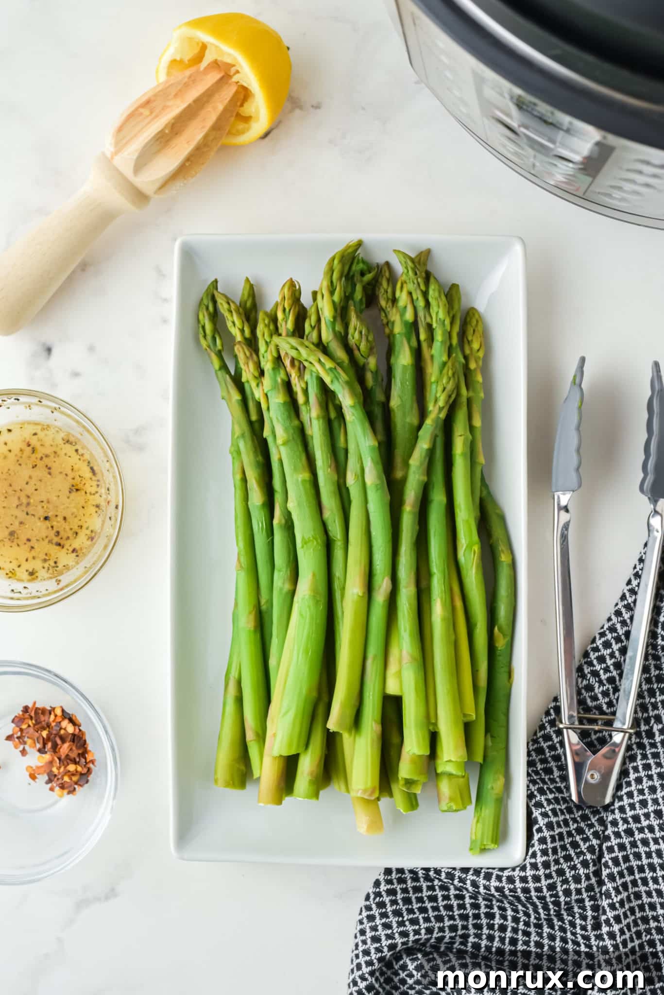 Prepared ingredients for Instant Pot asparagus spears laid out on a kitchen counter next to an Instant Pot.