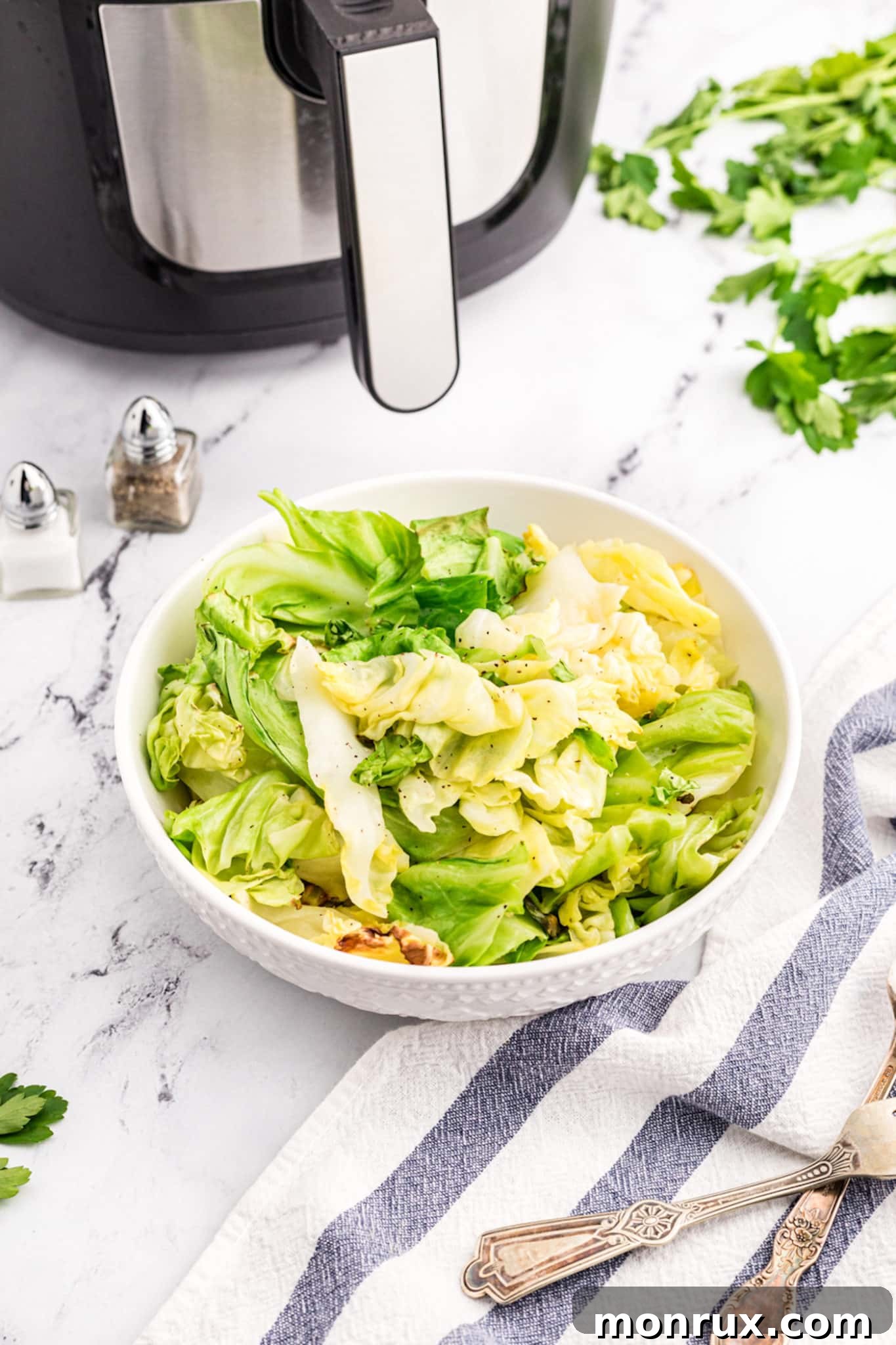 A beautifully arranged bowl of golden-brown air fryer chopped cabbage on a rustic countertop, ready to be served.